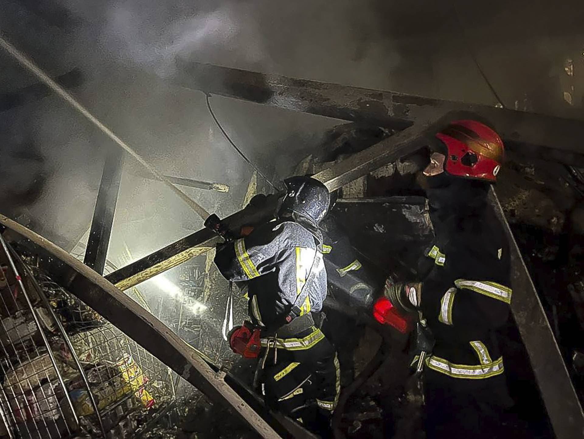 Emergency workers extinguish a fire after a Russian rocket hit in a storehouse building in Odesa