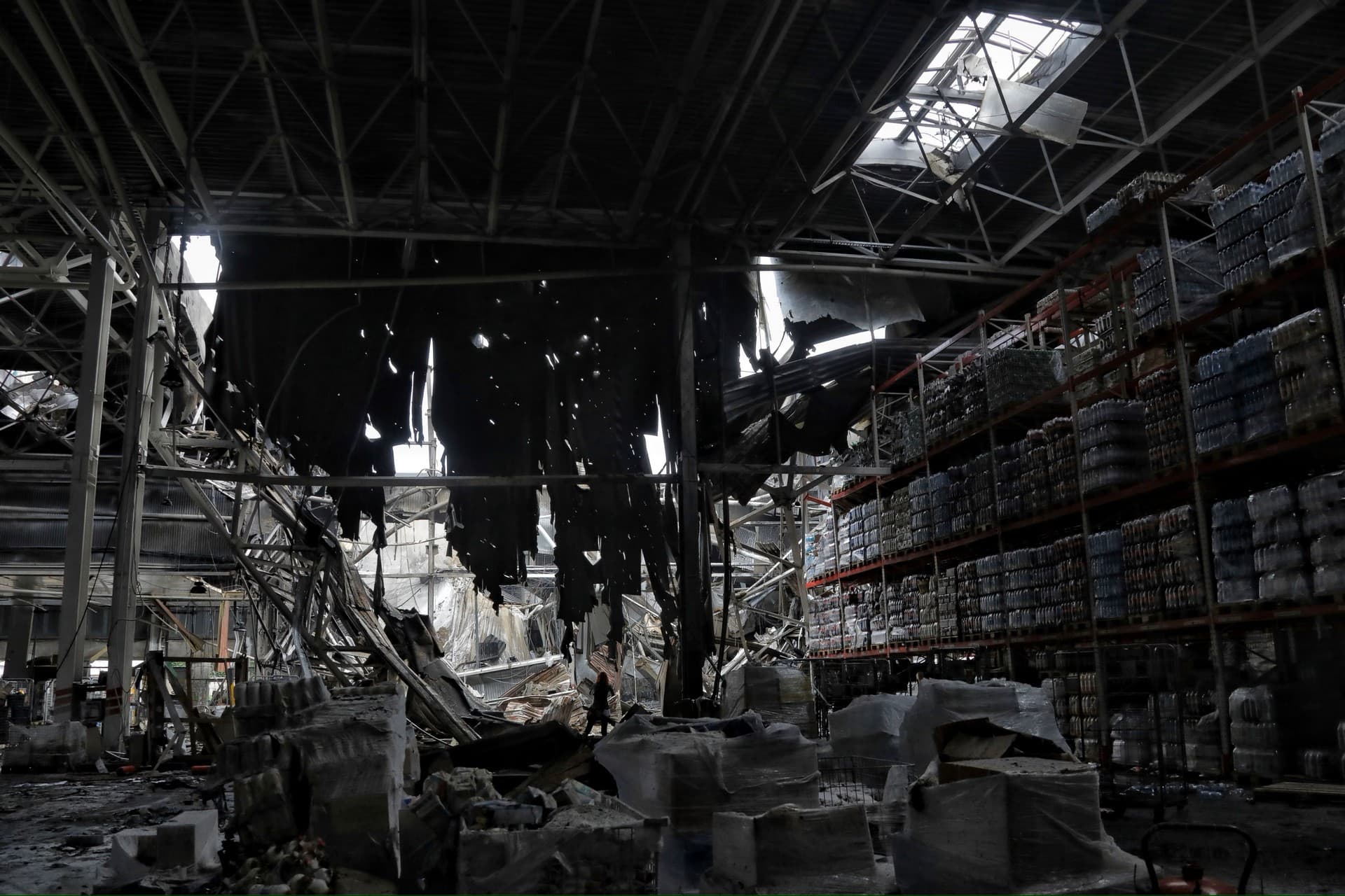 A person stands in a storehouse is damaged after a nightly Russian rocket attack in Odesa