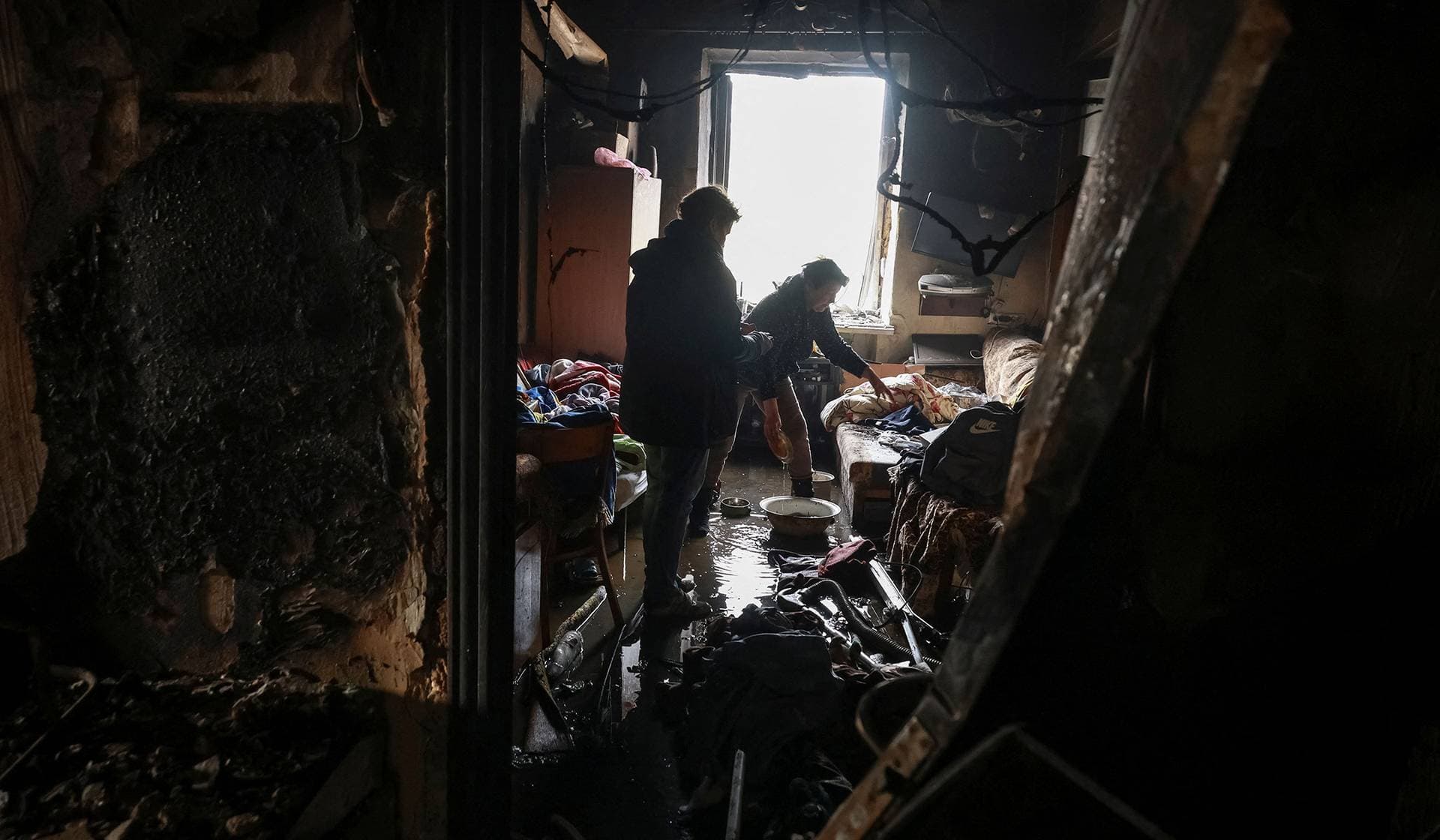 Residents clean a room in a dormitory hit by a Russian drone strike in Odesa