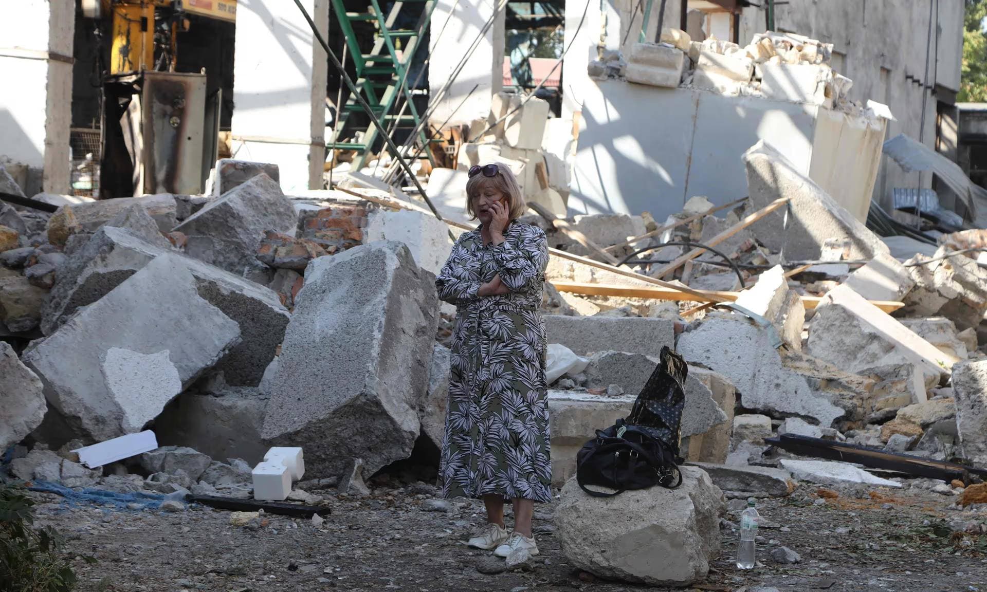A woman talks on a mobile phone next an industrial building damaged after a Russian attack on the Odesa region