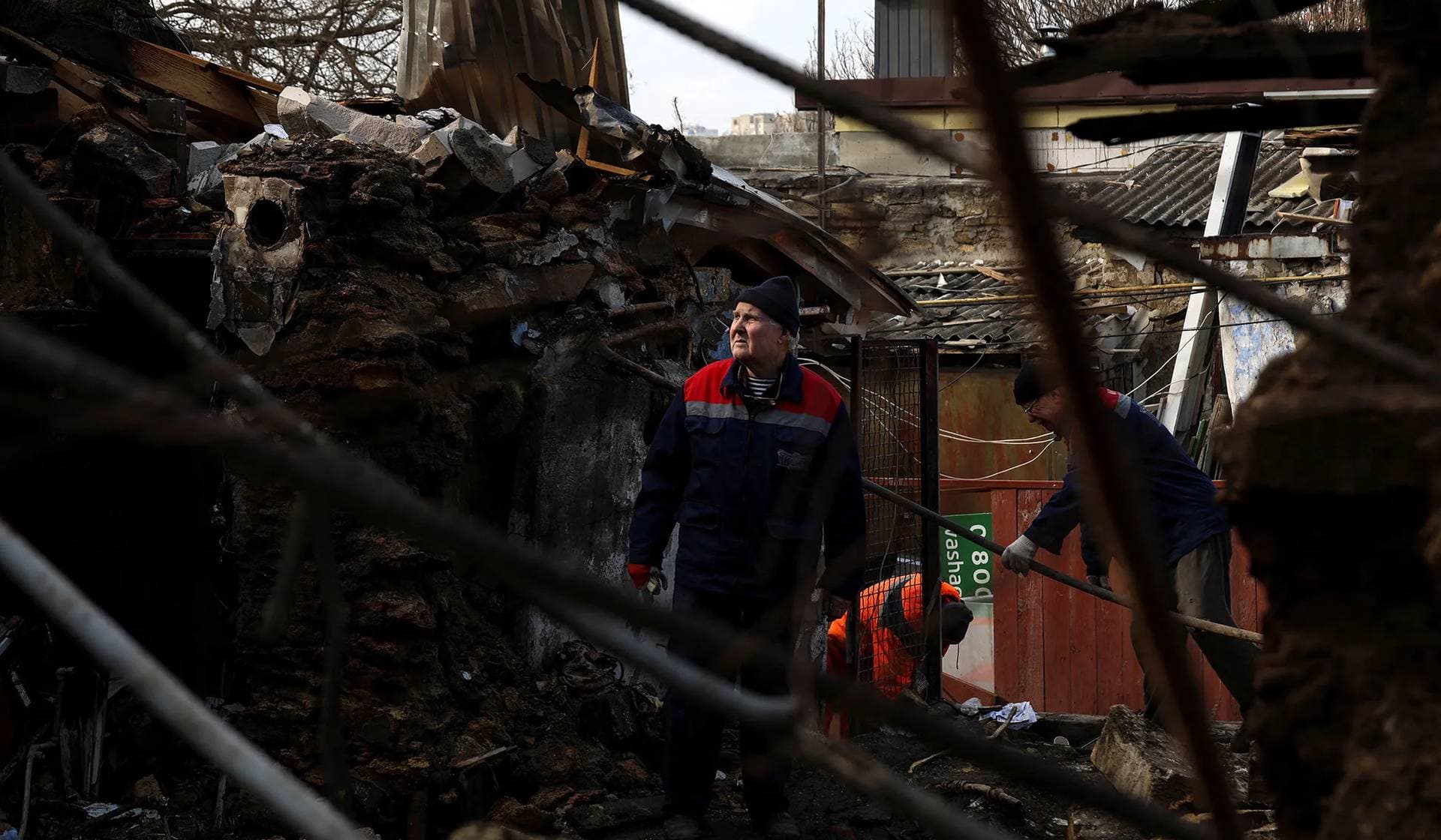 Municipal workers remove debris at the site of a residential building heavily damaged by a Russian drone strike in Odesa