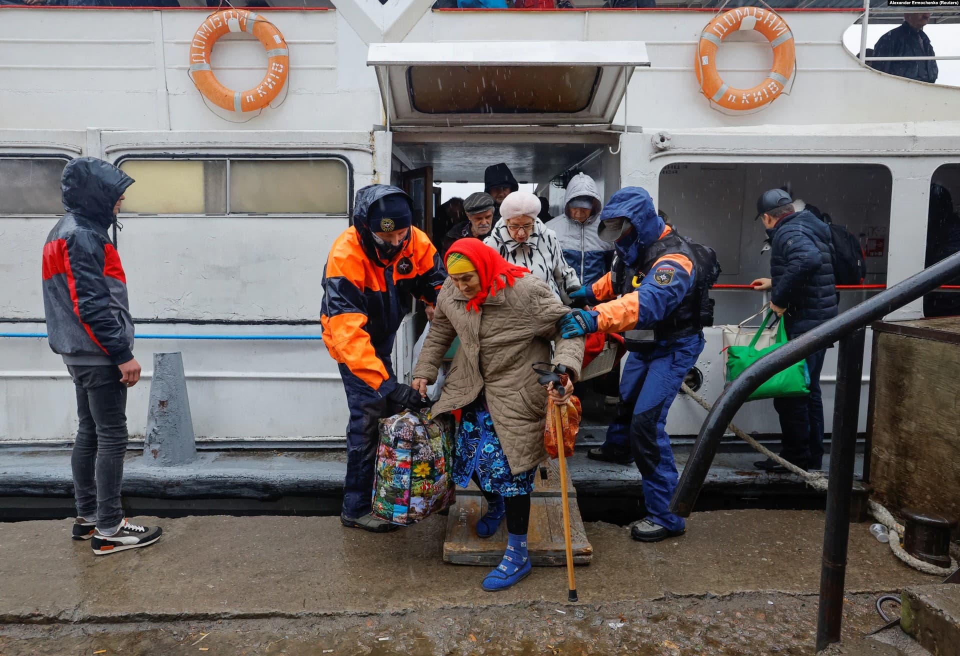 An elderly woman steps off a boat at Oleshky during the evacuation from Kherson