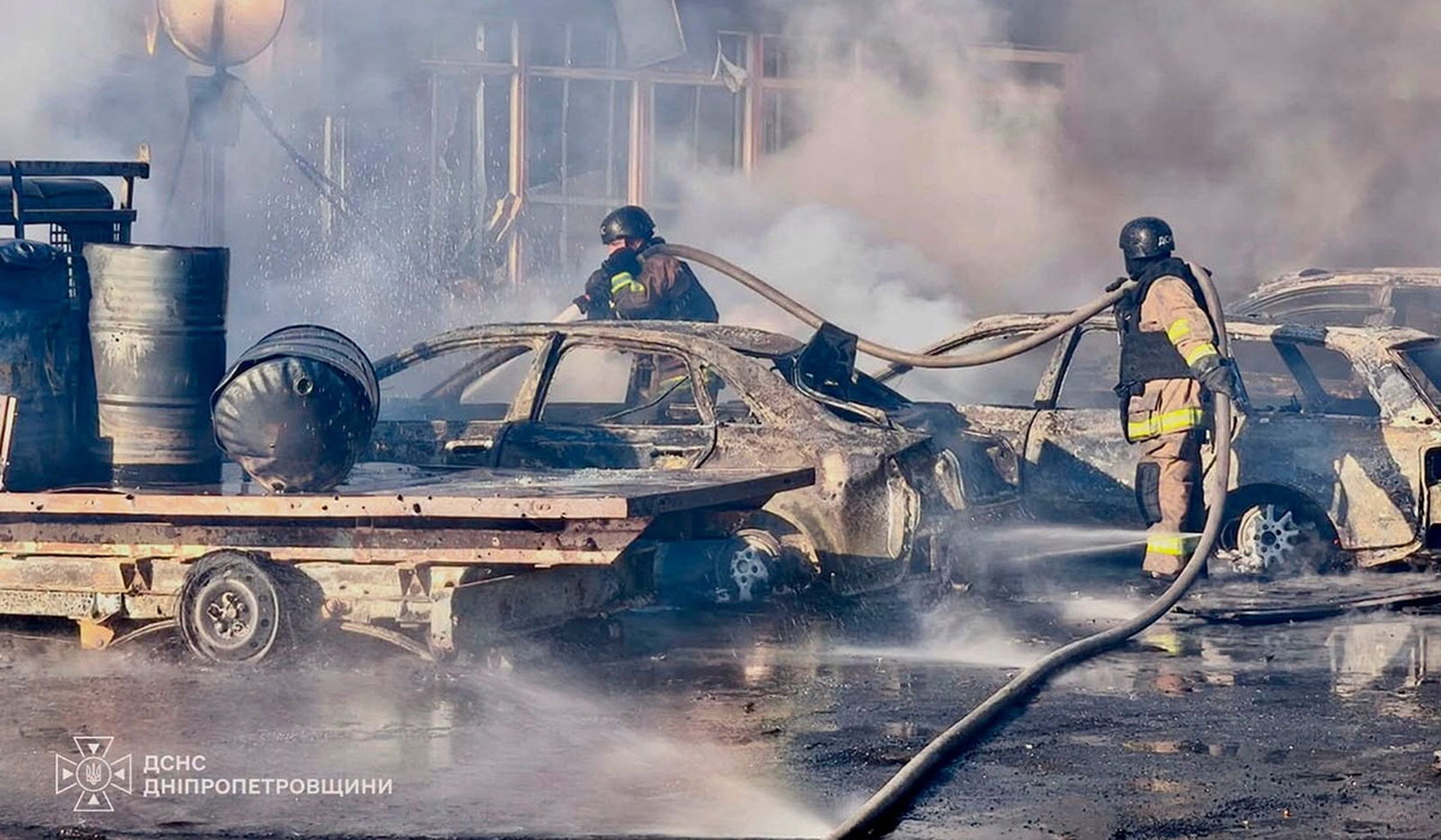 Firefighters work at the site of shops and a market hit by a Russian drone strike in the city of Pavlohrad