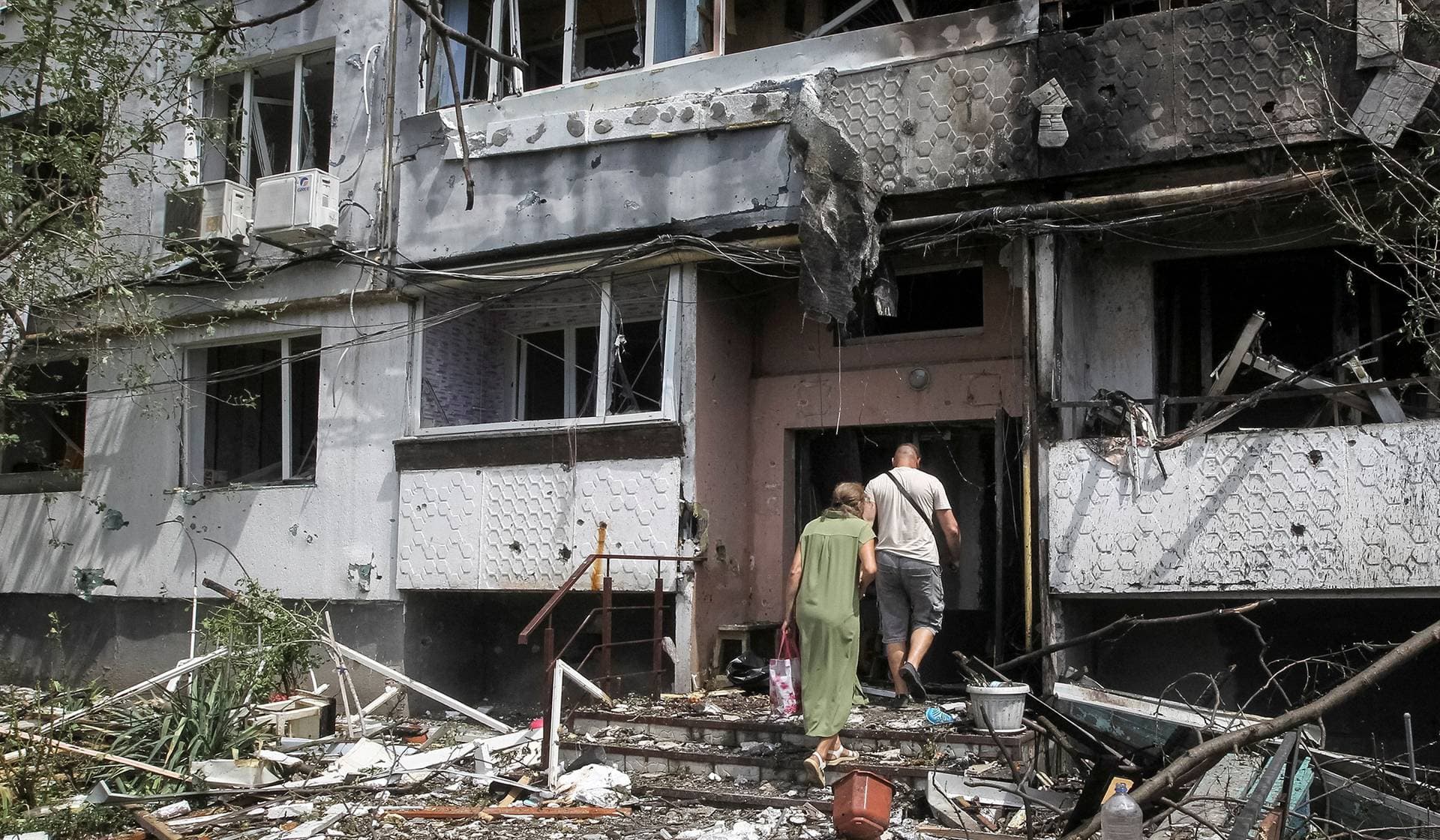 Residents enter their apartment building hit by a Russian air strike in Pavlohrad
