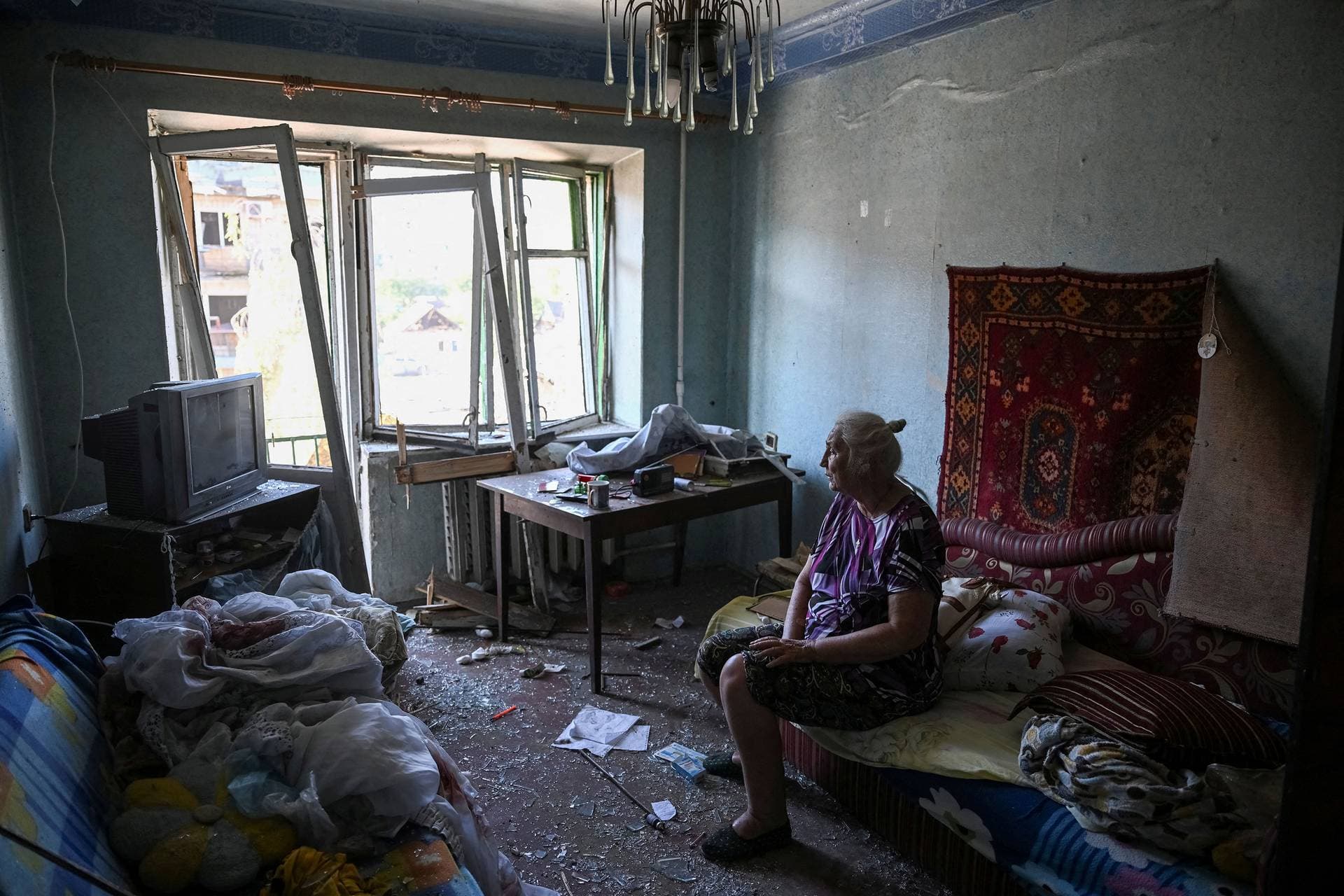 A woman sits in her destroyed apartment in a building struck by a Russian missile strike in Pokrovsk