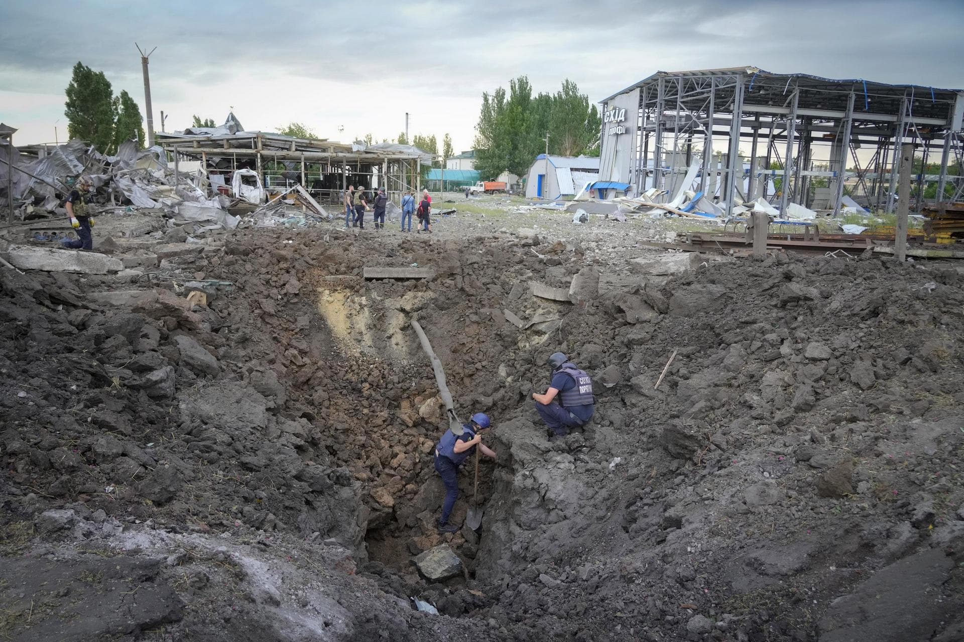 Police members inspect a crater caused by a Russian rocket attack in Pokrovsk