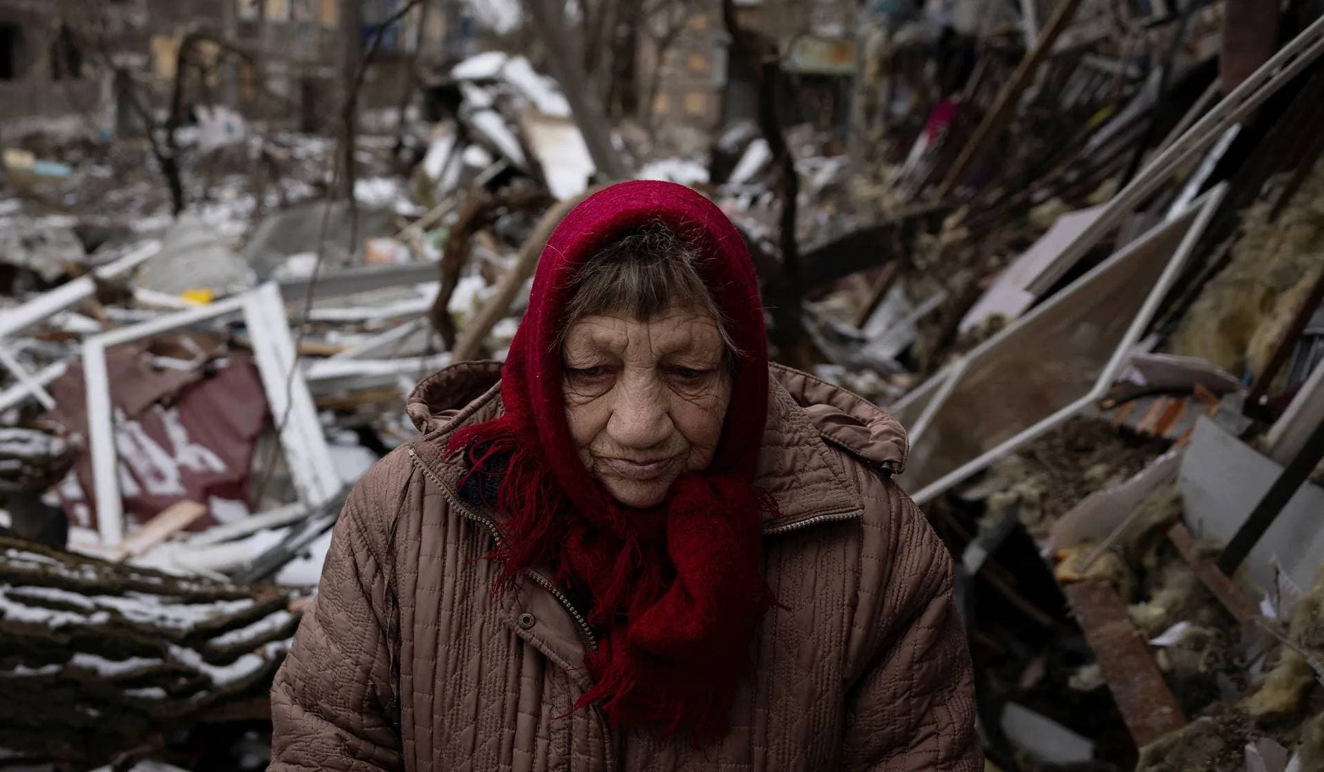 Raisa Nazarenko stands in front of her shattered ground floor apartment that was damaged as a result of a Russian missile strike in Selydove