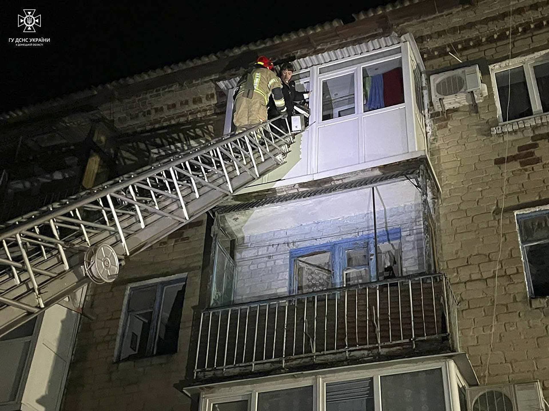 A rescuer evacuates a civilian from an apartment building damaged at night by Russian missile strike in Selydove