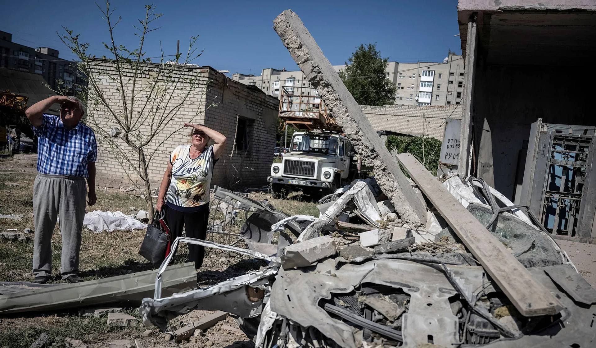 Local residents stand outside an apartment building damaged by a Russian missile strike in Pokrovsk