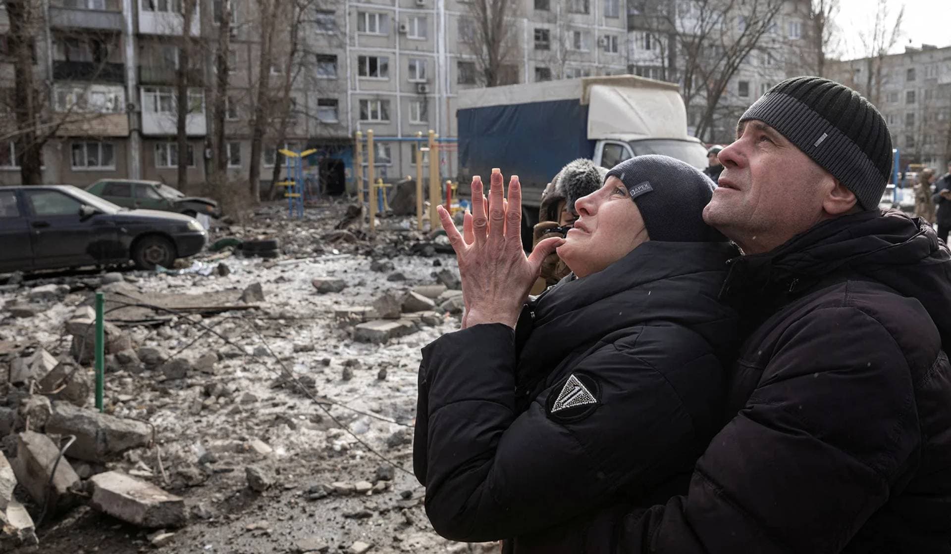 A woman reacts as her brother is rescued after an apartment block was heavily damaged by a missile strike in Pokrovsk