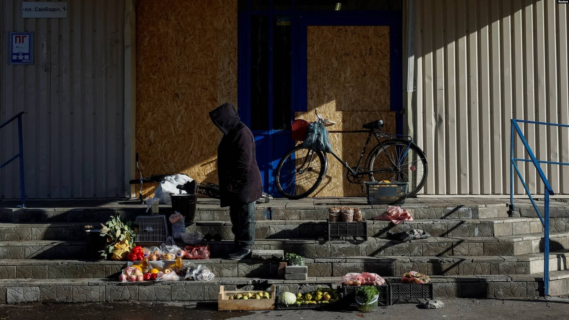 A woman sells vegetables on the steps of a closed supermarket amid Russia's attack on Ukraine in Pokrovsk