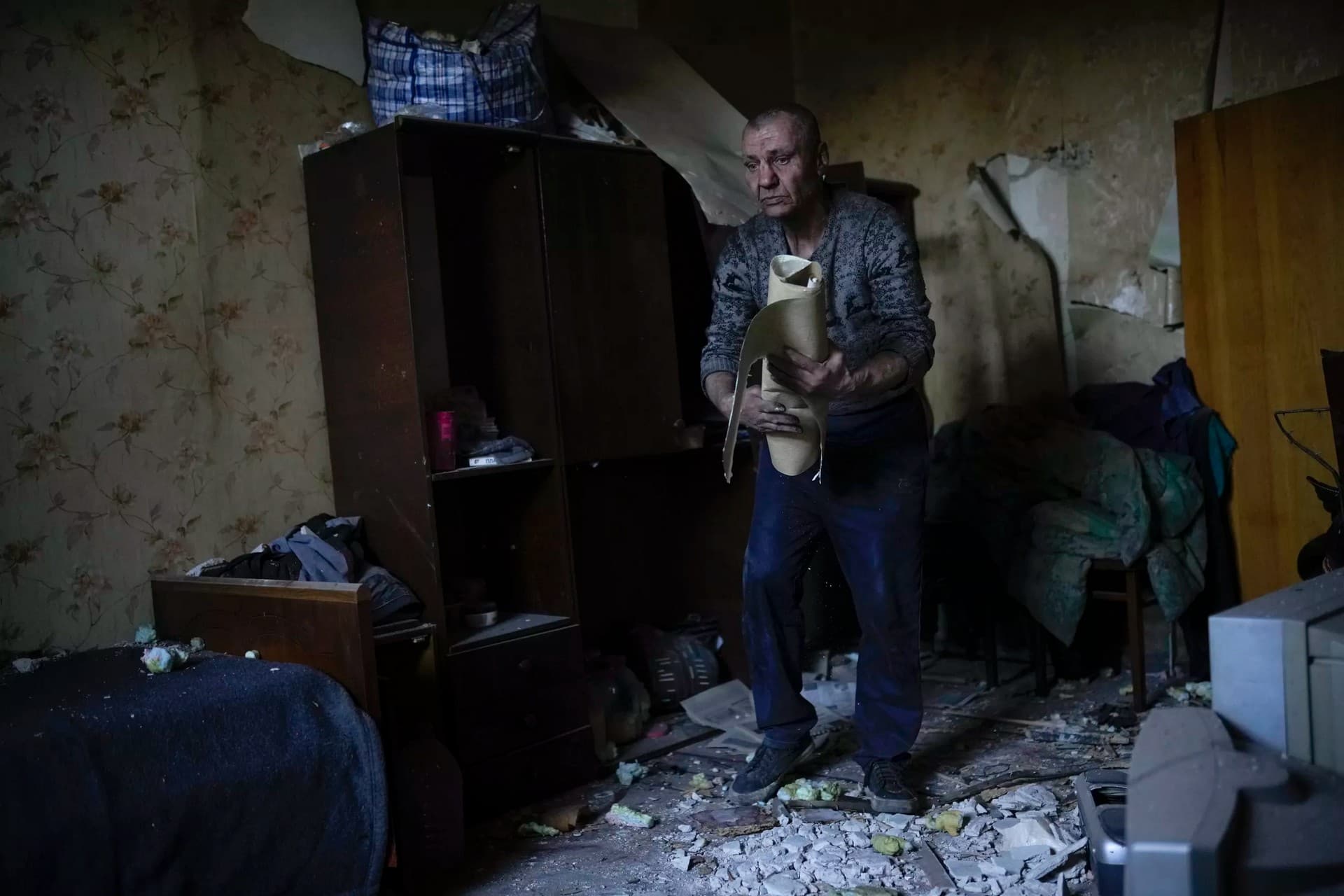 A local resident gathers up belongings from his heavily damaged house after a Russian strike in Pokrovsk