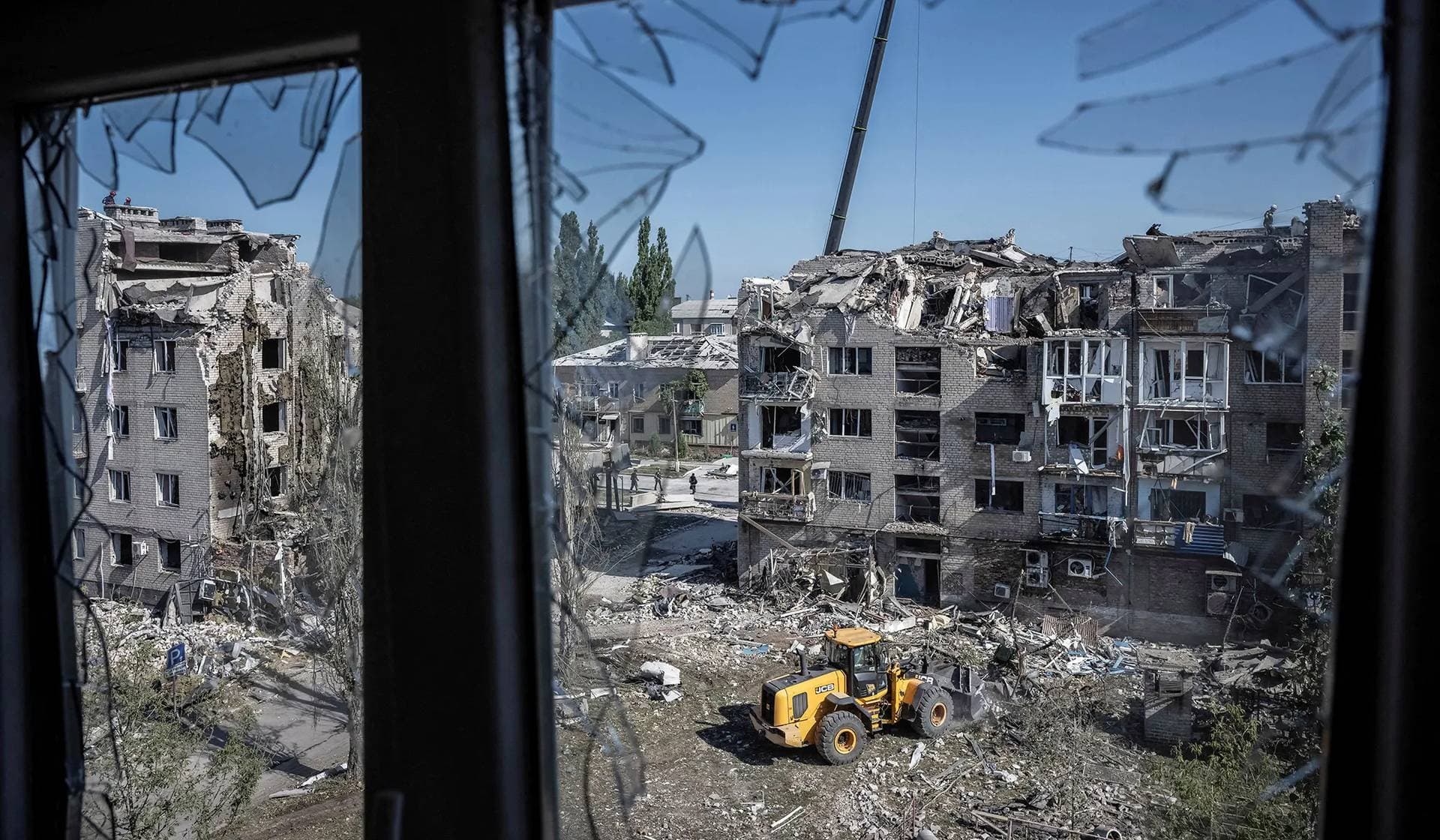 Rescuers work with heavy machinery at the site of a building destroyed during a Russian missile strike in Pokrovsk