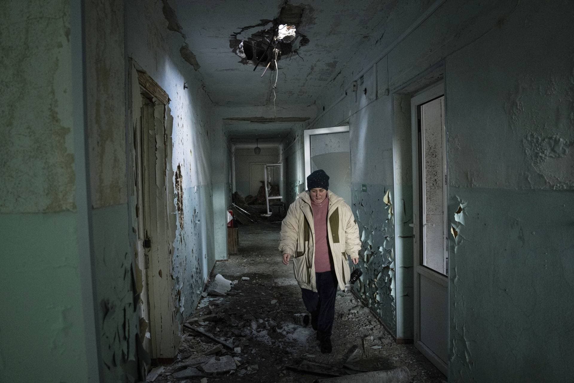 Valentyna Mozgova, a lab medic walks in the corridor of a hospital which was damaged by Russian shelling in Krasnohorivka