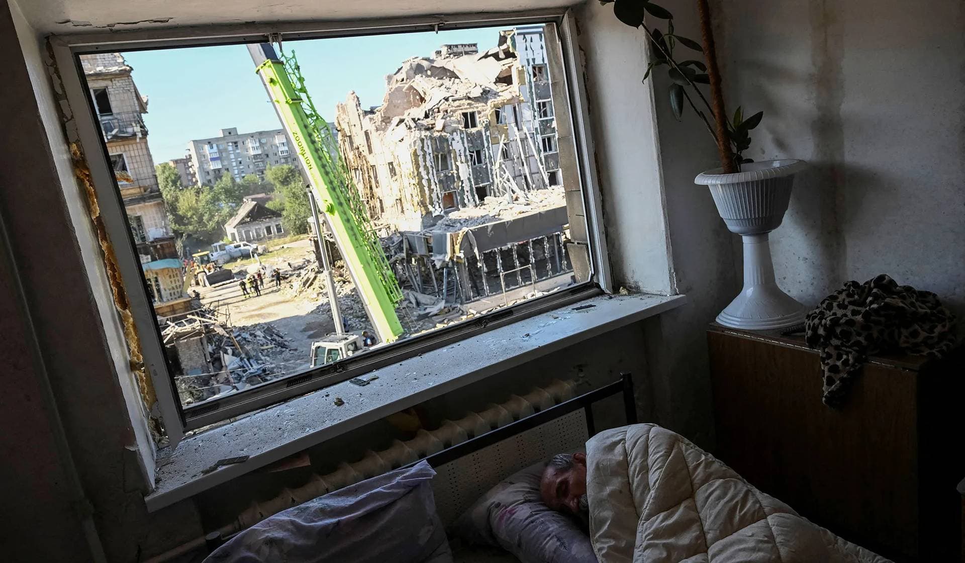 A local resident sleeps in his apartment in a building damaged during a Russian missile strike in Pokrovsk