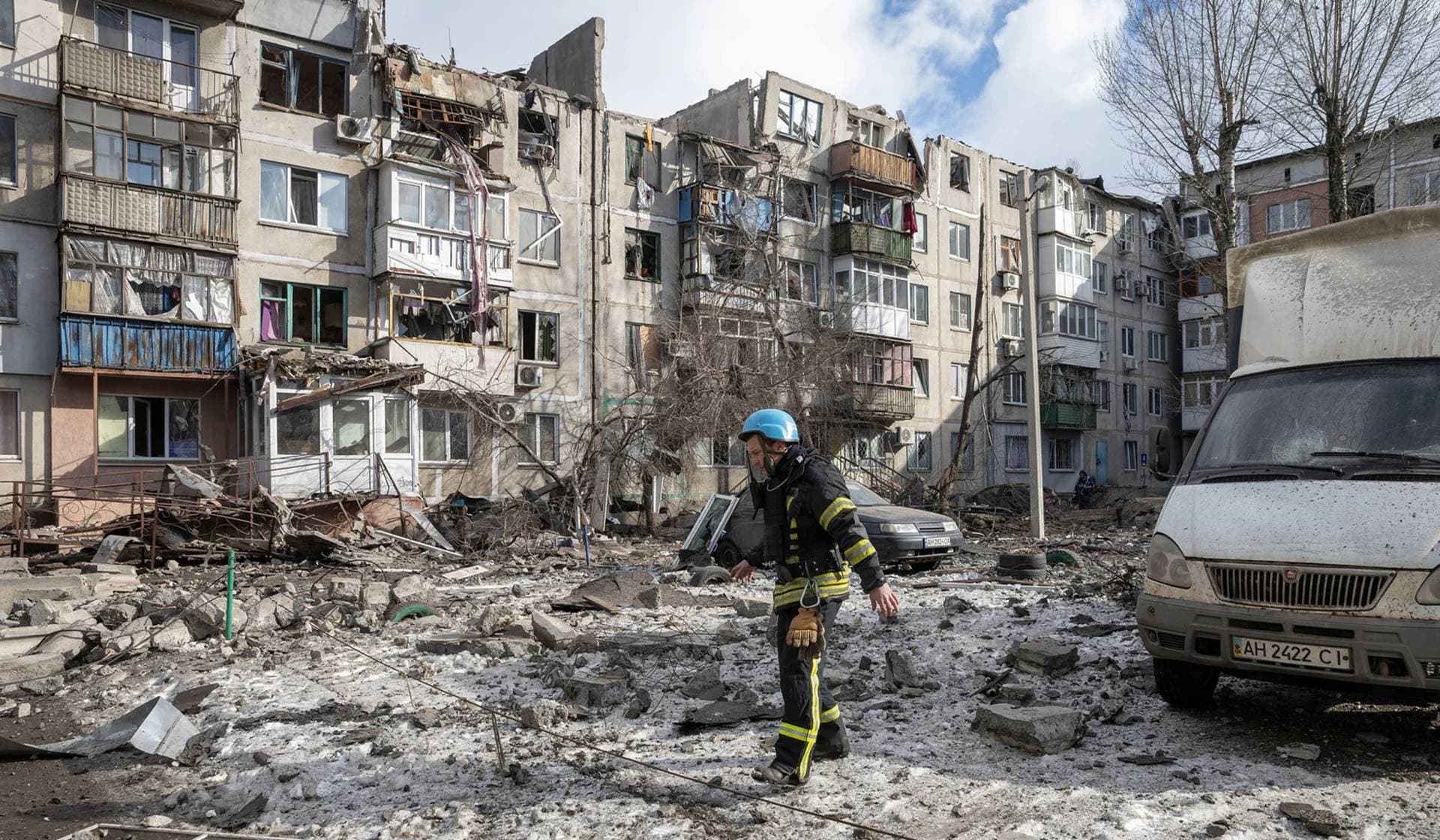 A firefighter walks at a car park near an apartment block that was heavily damaged by a missile strike in Pokrovsk