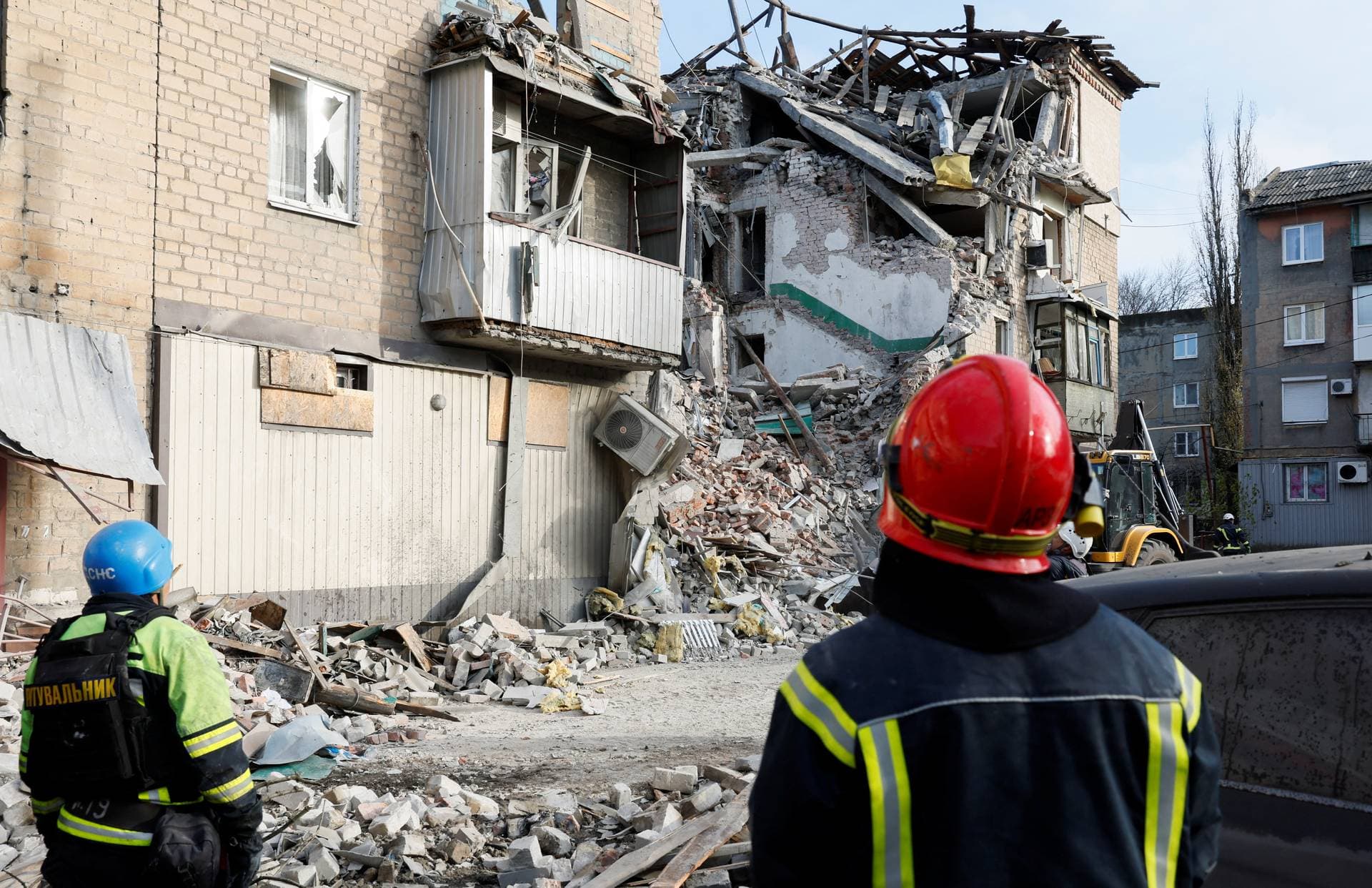 Rescuers look at the site of residential houses heavily damaged by a Russian missile strike in the town of Selydove