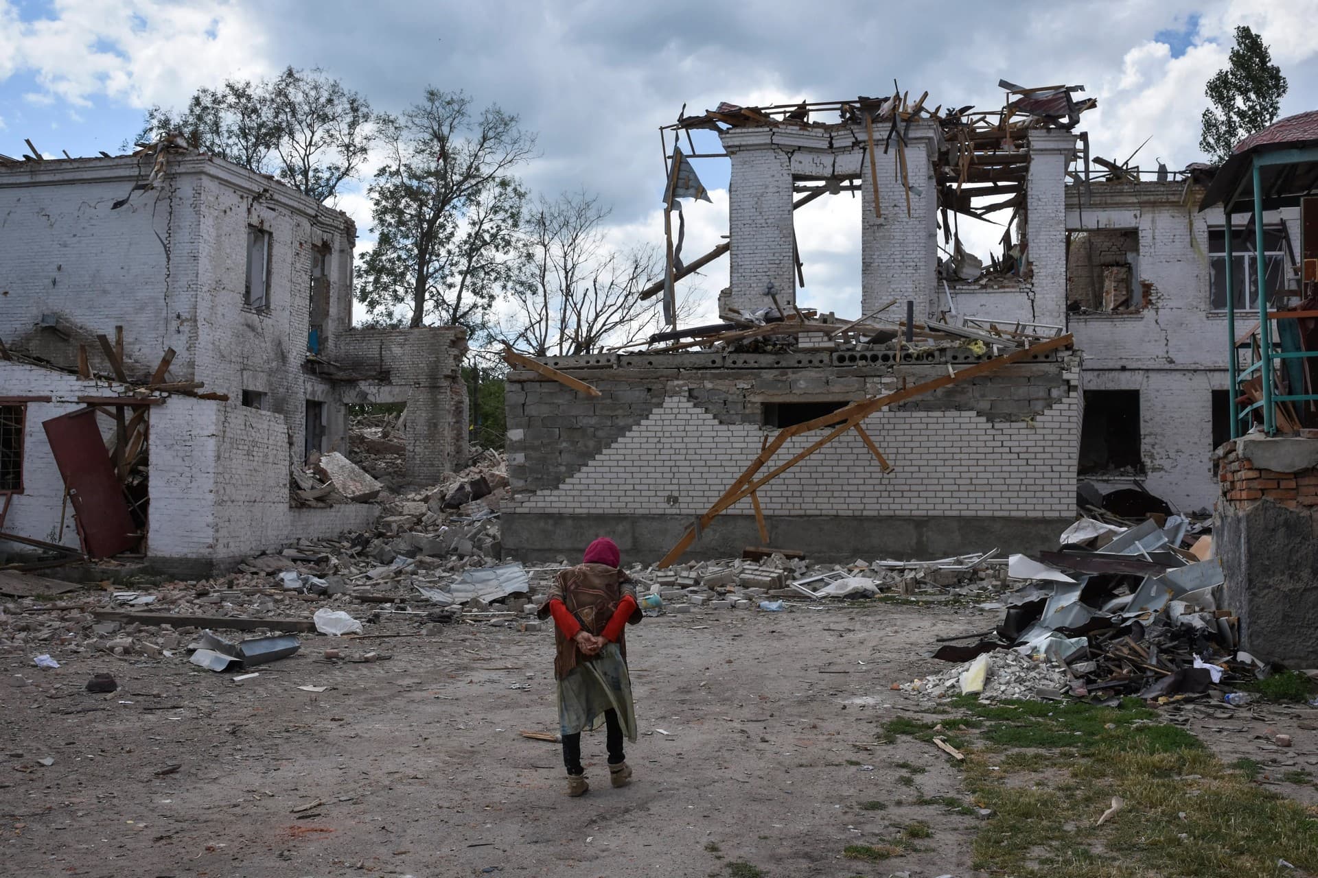 An elderly woman walks next to buildings destroyed in a Russian strike in the town of Orikhiv