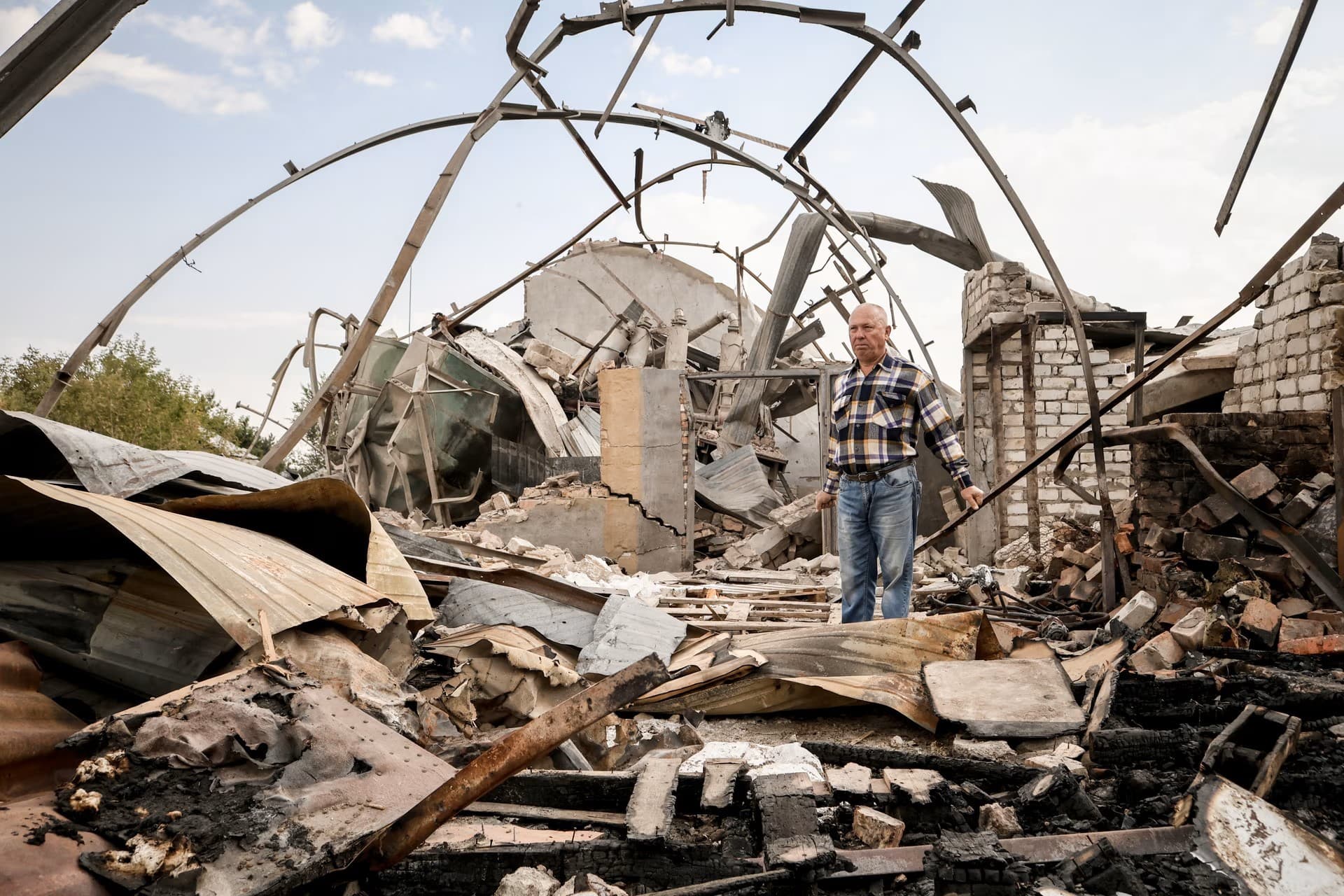 Ukrainian farmer inspects the rubble of a destroyed grain storage on his farm, near the frontline town of Orikhiv