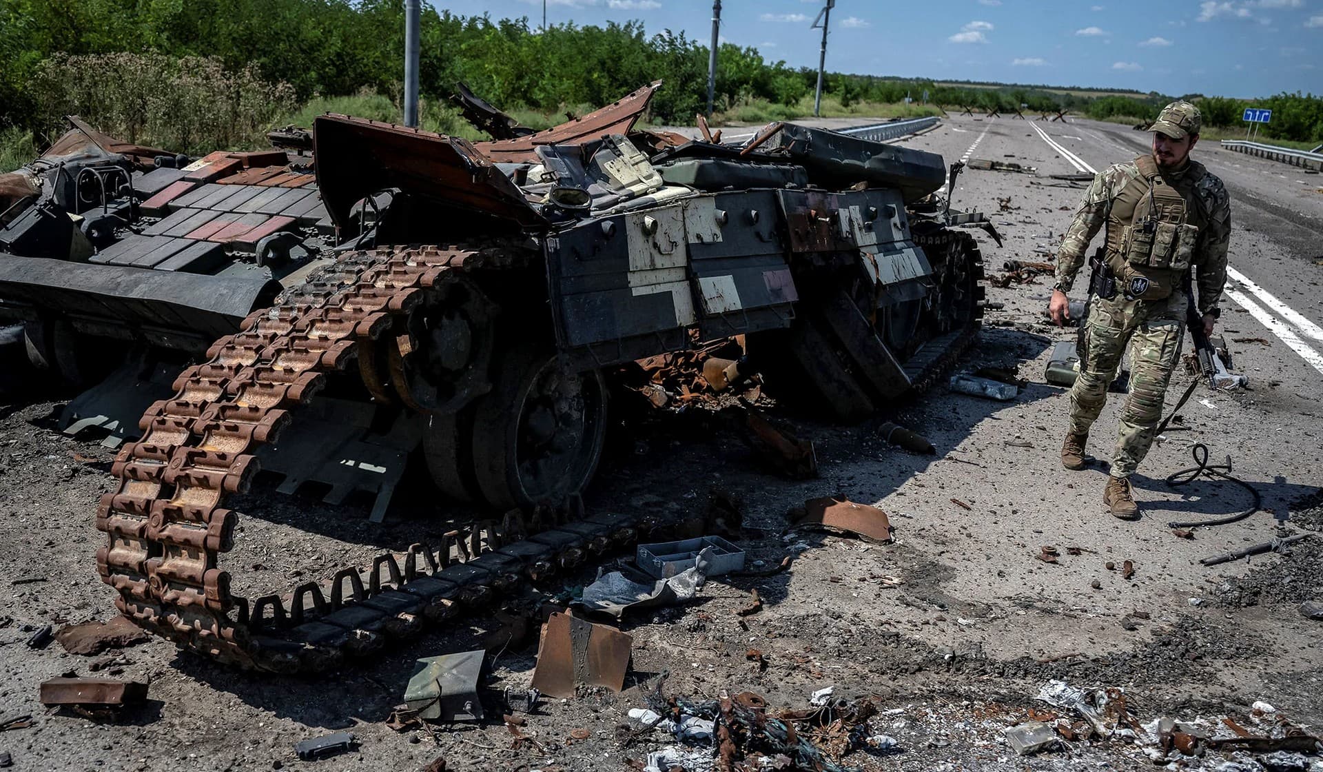 A Ukrainian serviceman walks near a destroyed Ukrainian tank, near the village of Robotyne