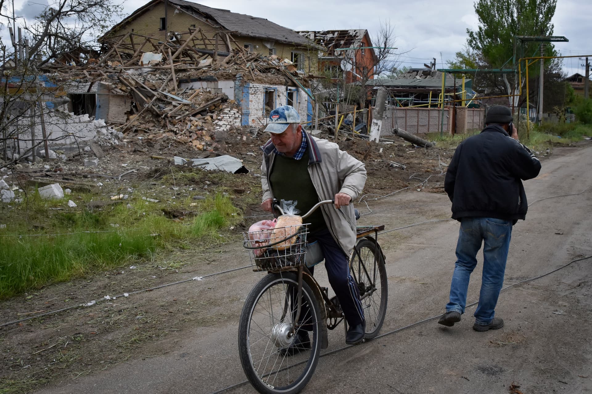 A local resident rides a bike past a house damaged in a Russian air raid in Orihiv