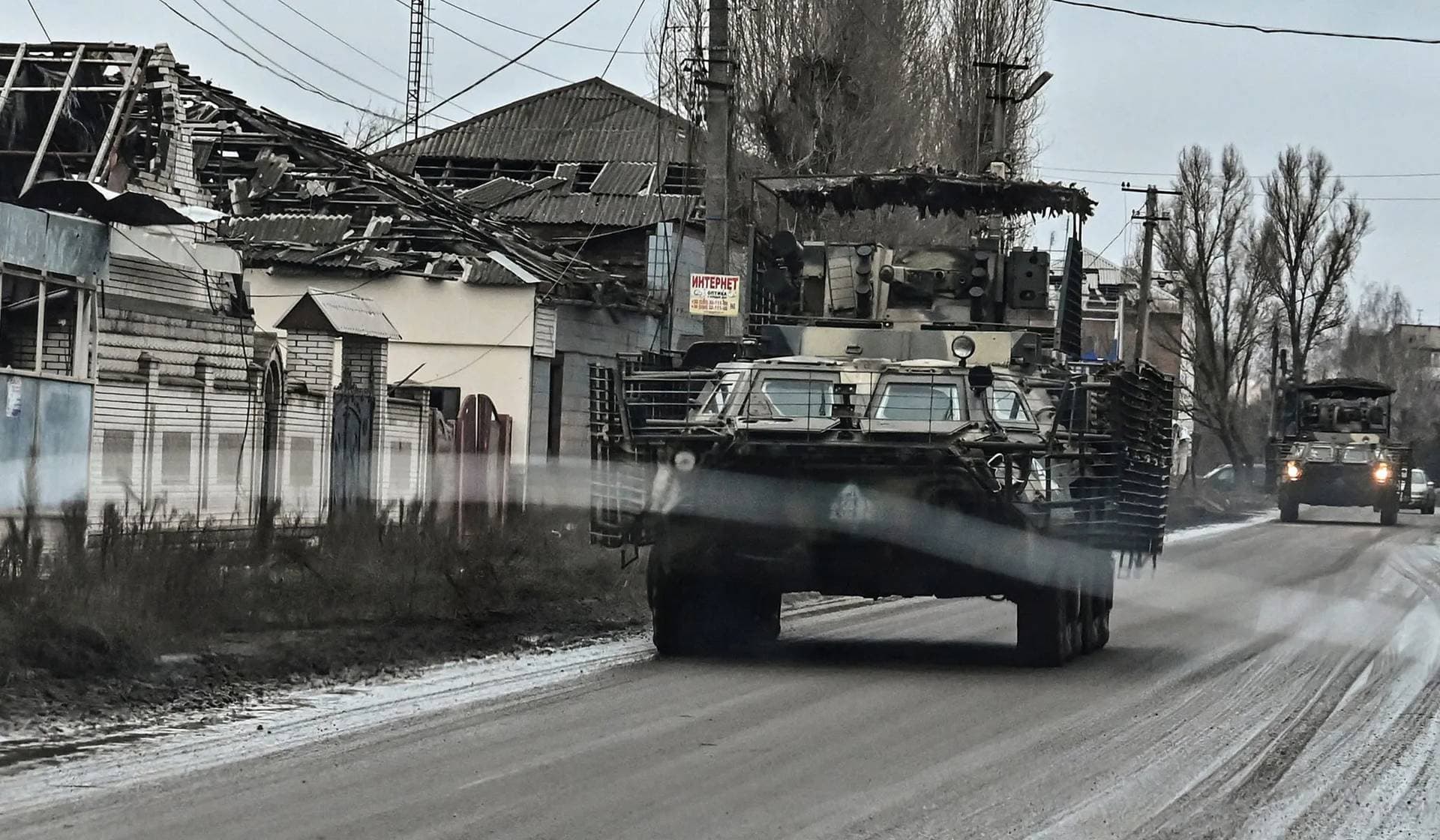 Ukrainian servicemen drive BTR-4 armored personnel carriers along a road in the town of Orikhiv