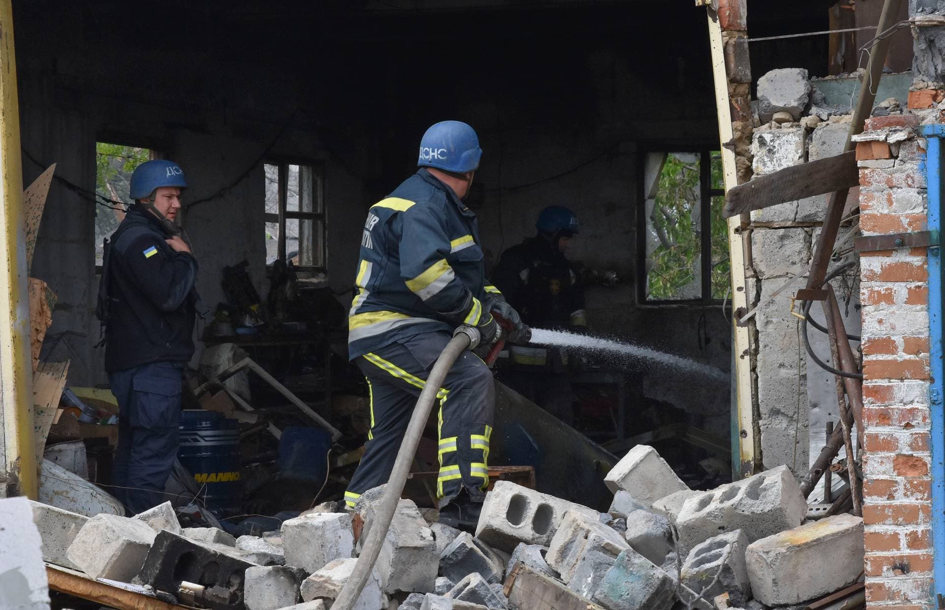 Ukrainian State Emergency Service firefighters put out fire after a Russian air raid hit apartment buildings in Orihiv