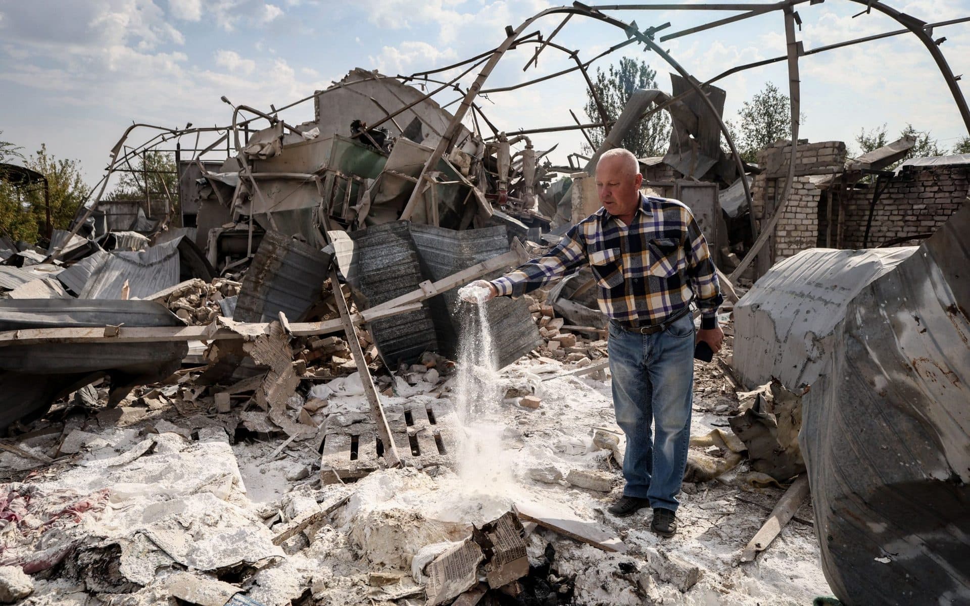 A Ukrainian farmer inspects the rubble of a destroyed mill on his farm, near the frontline town of Orikhiv
