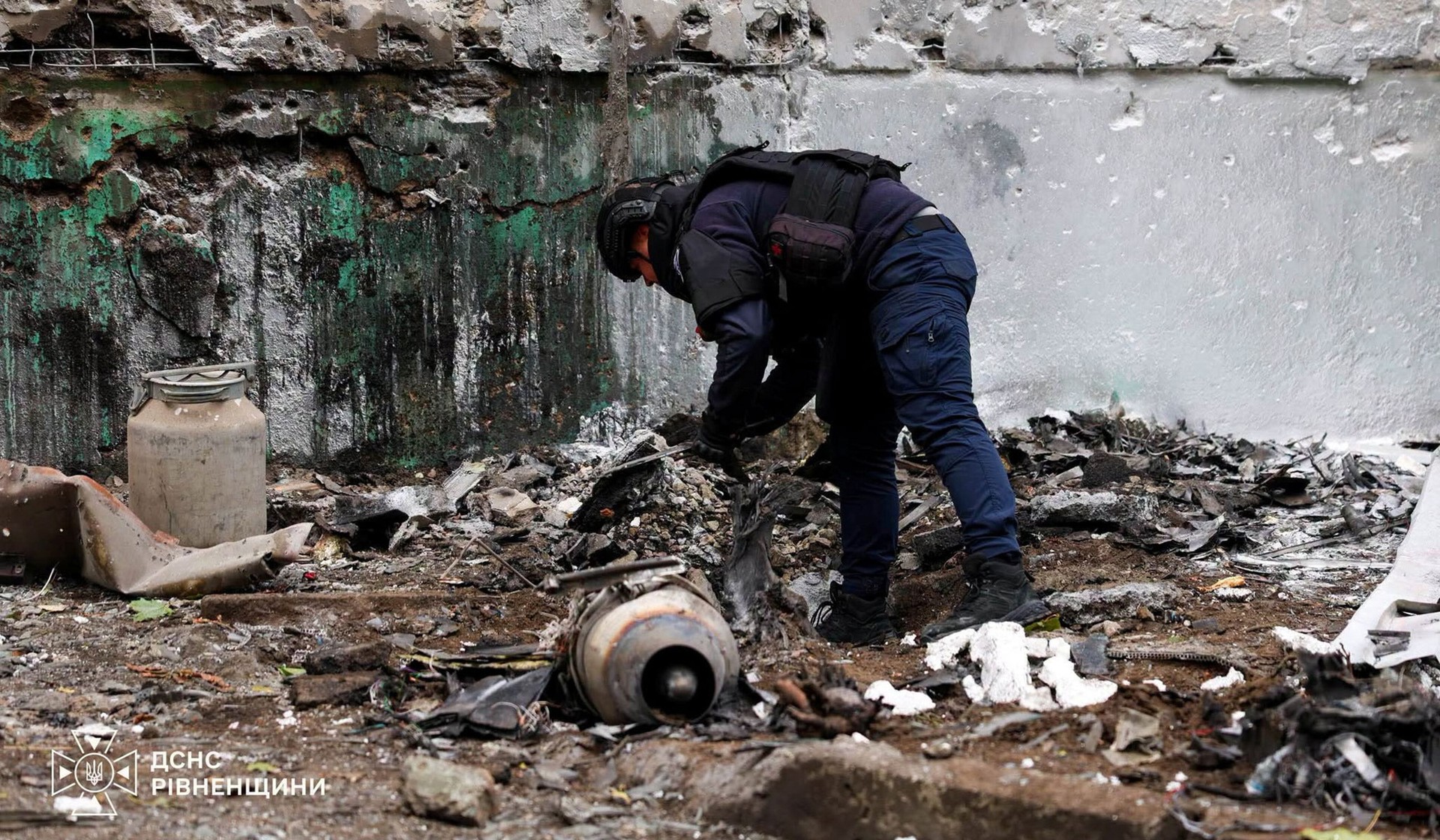 An emergency service deminer works at the site of an apartment building damaged during a Russian drone strike in Rivne Region