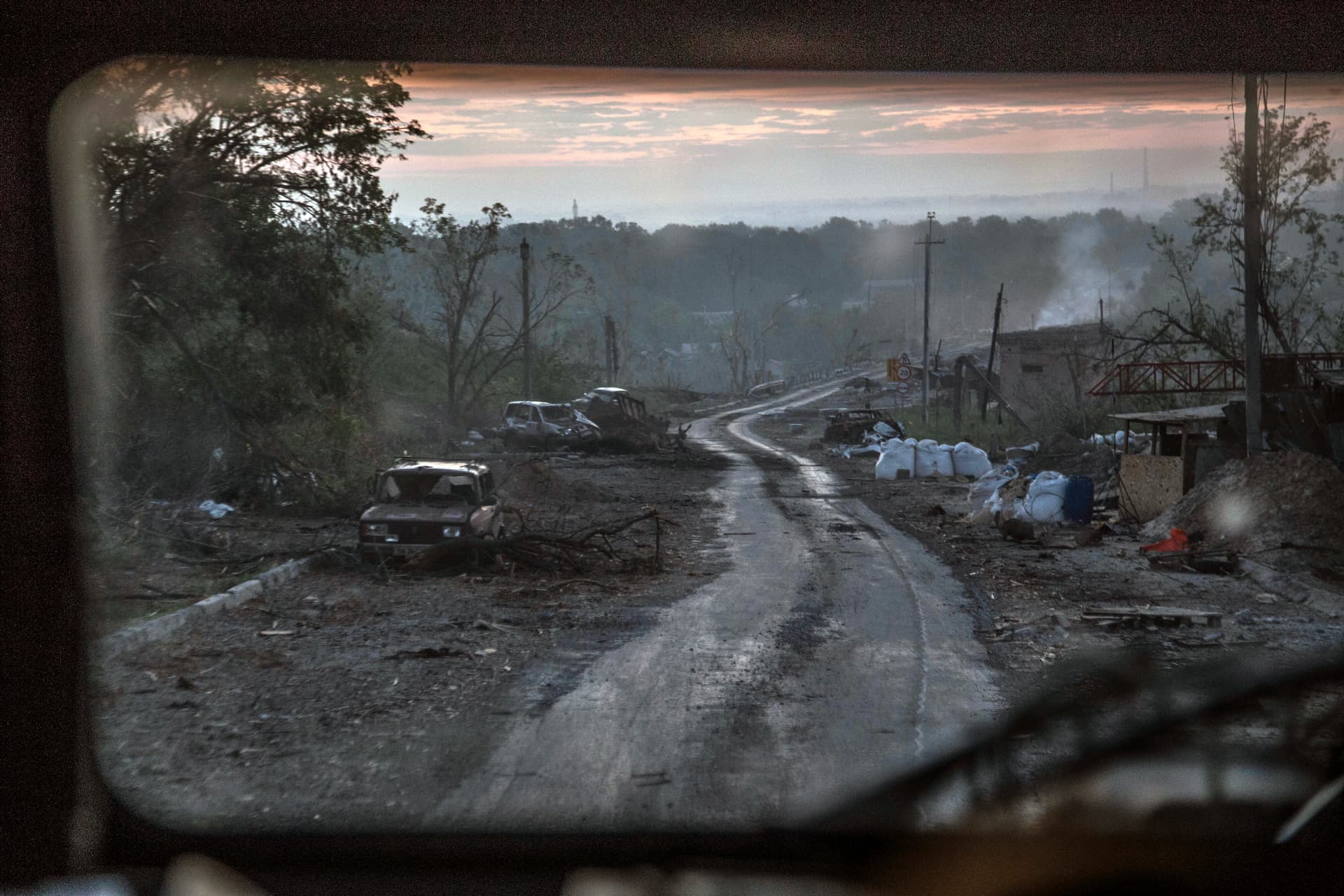 The gutted remains of cars sit along a road during heavy fighting at the front line in Severodonetsk