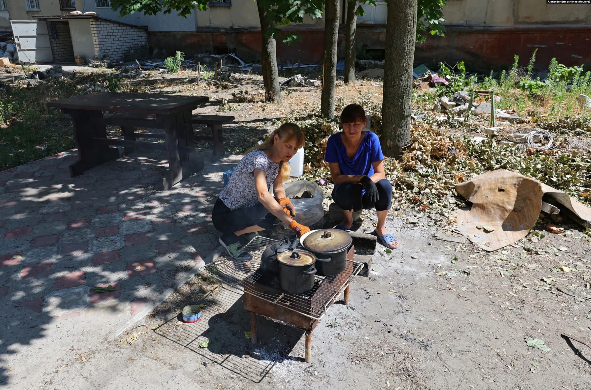 Local residents cook food on an open fire