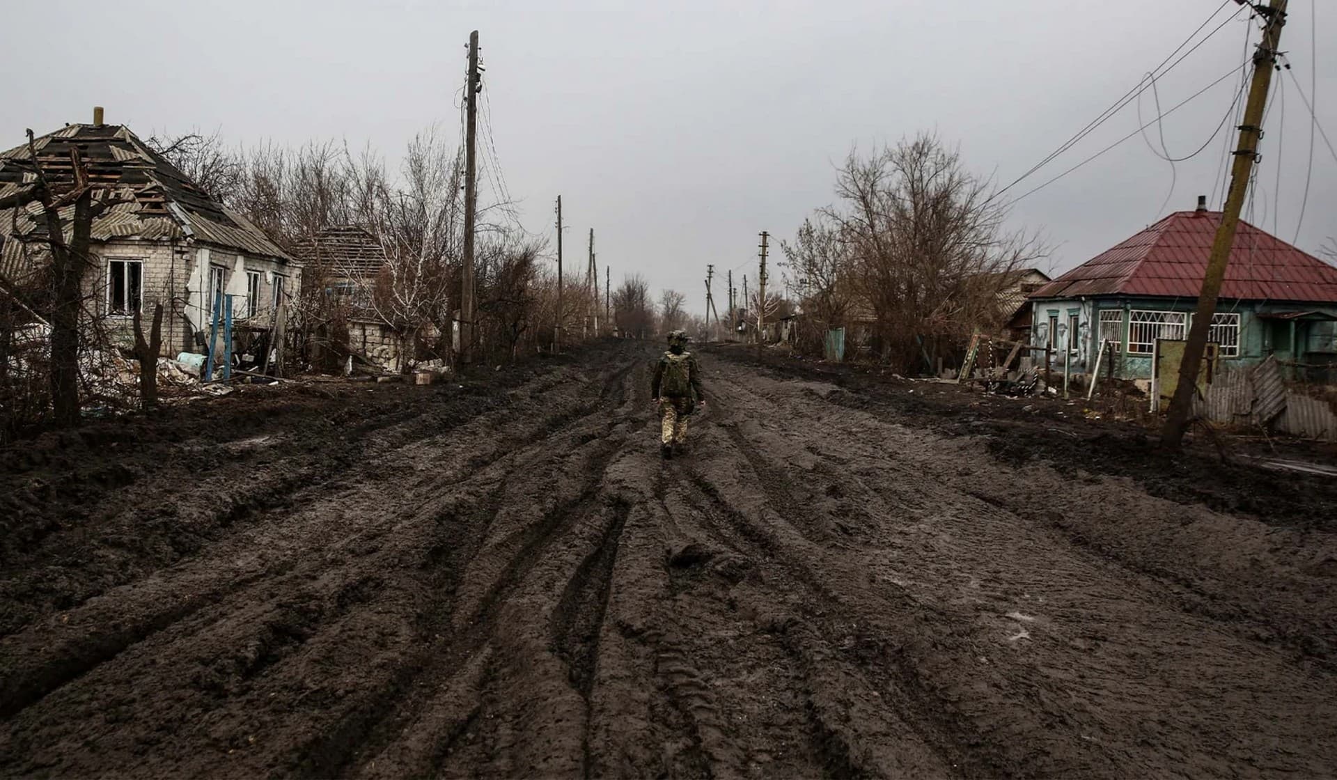 A Ukrainian serviceman walks along a street in a village near the frontline town of Kreminna