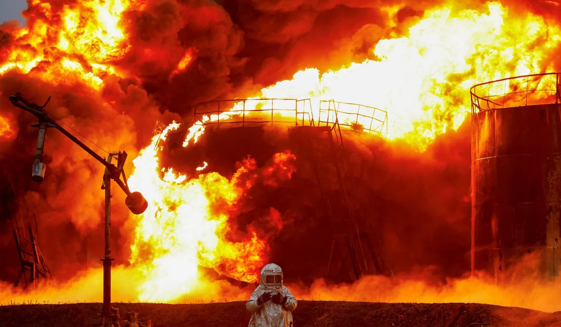 A firefighter works to extinguish fire following recent shelling at an oil storage facility in Shakhtarsk