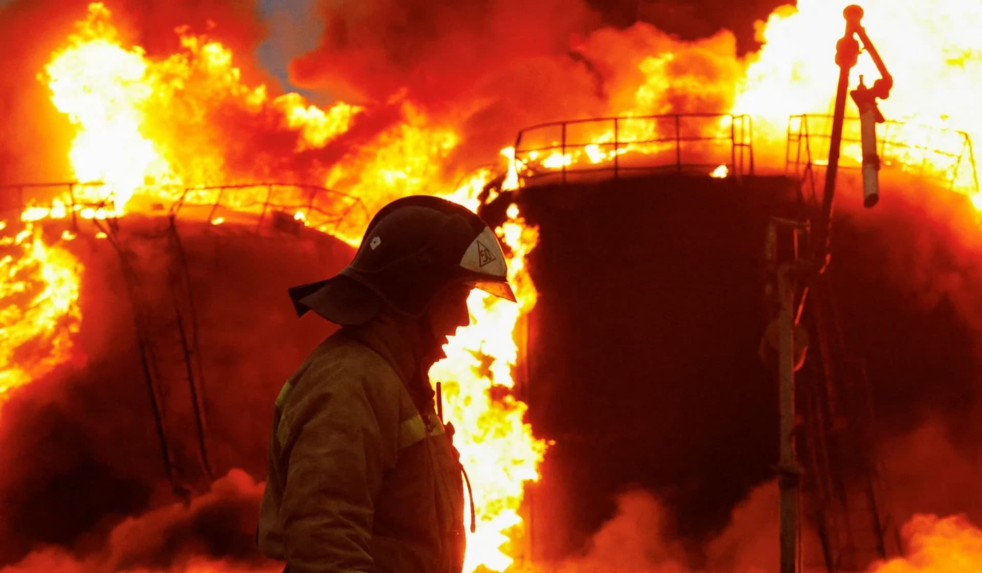 A firefighter works to extinguish fire following recent shelling at an oil storage facility in Shakhtarsk
