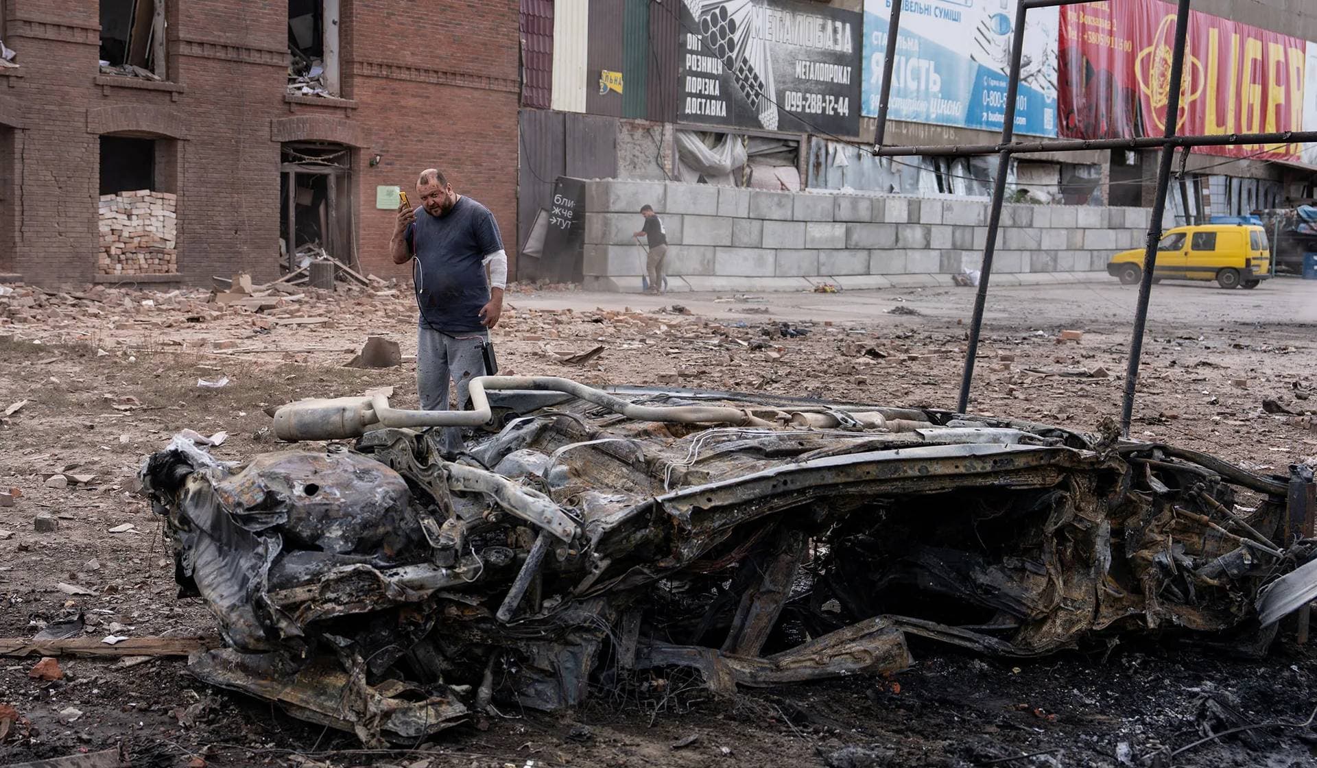 A wounded resident walks at a site of a Russian air strike in the frontline city of Sloviansk