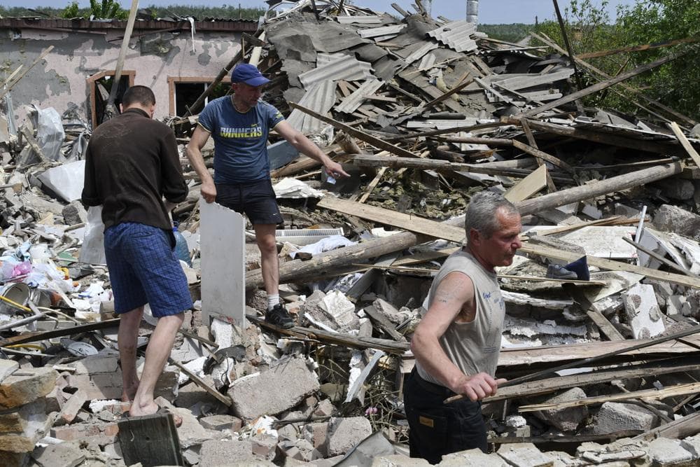 People clean an area of a building damaged by an overnight missile strike in Sloviansk