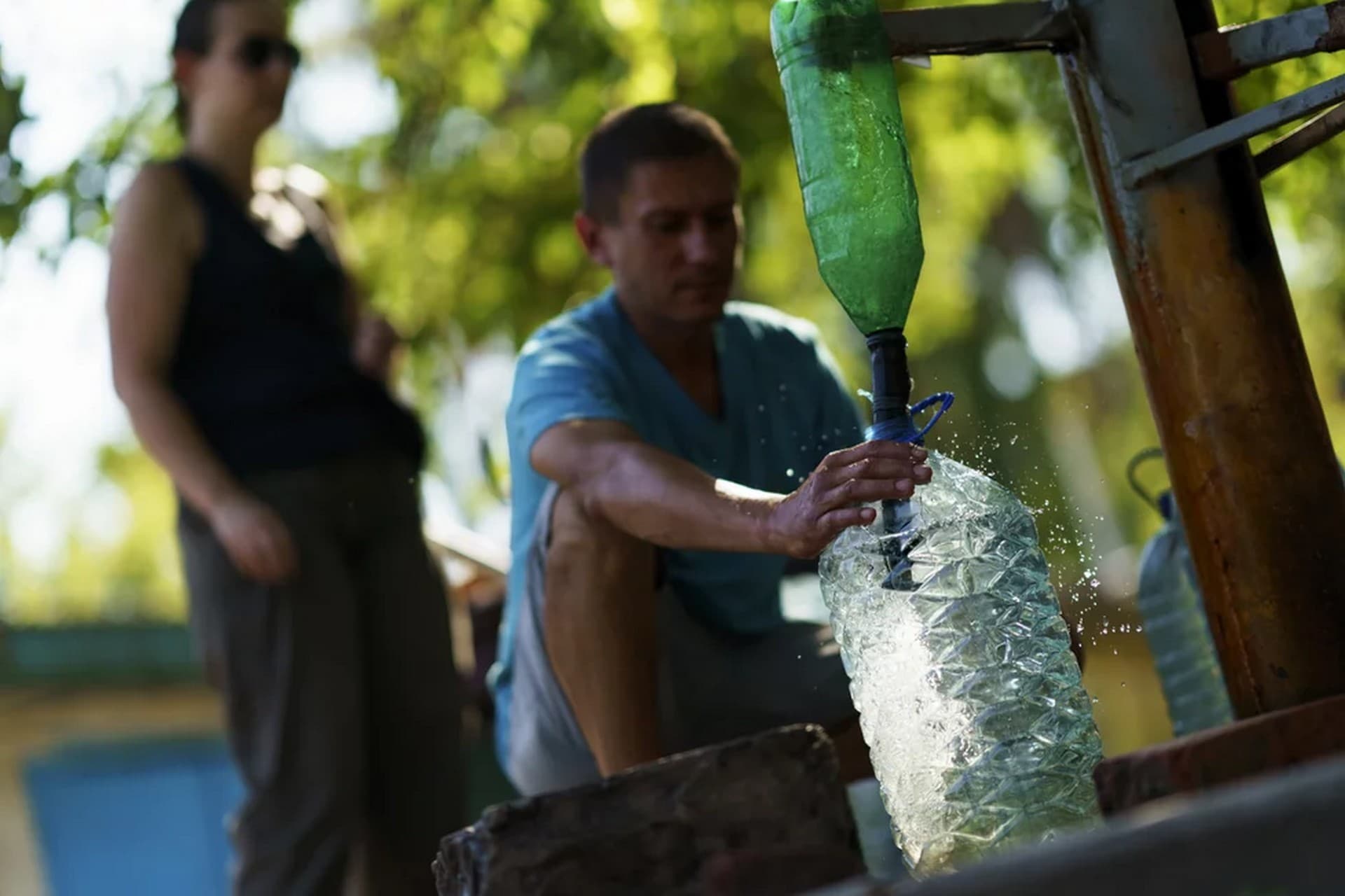 Residents gather to pump water from a well outside an apartment complex in Sloviansk