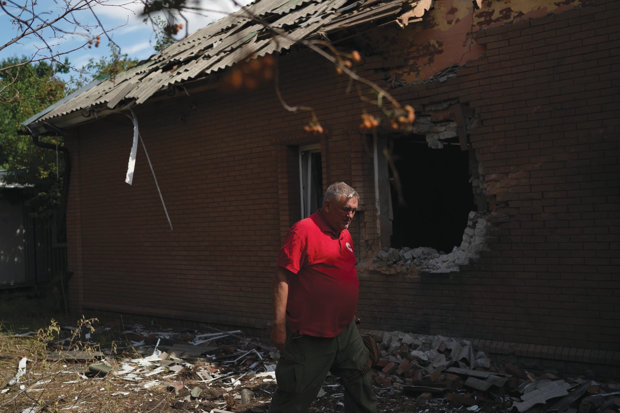 The head of the rapid response unit Taras Logginov walks in front of the damaged building of the Ukrainian Red Cross Society that was hit last week during a Russian attack in Sloviansk