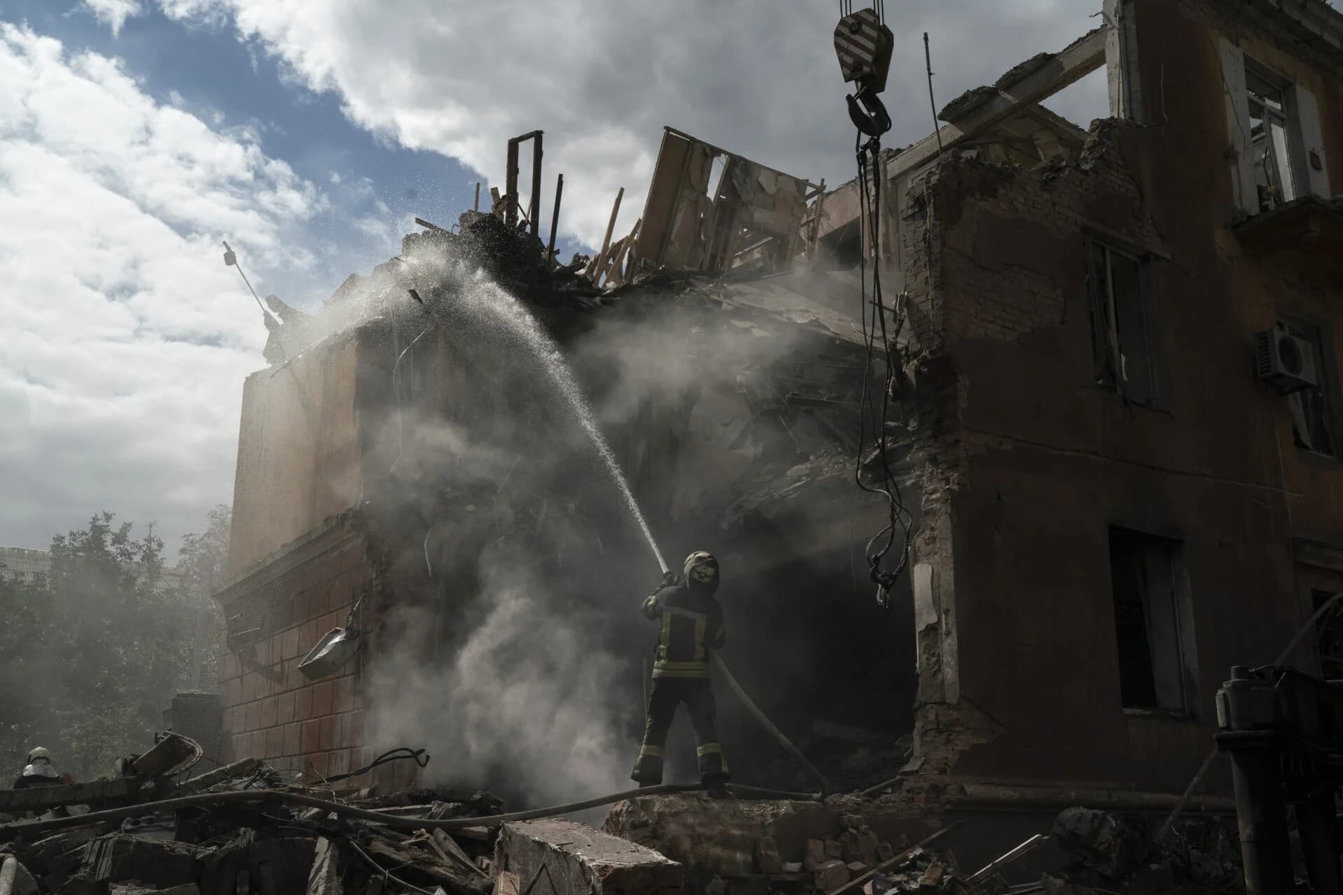 A firefighter works to extinguish a fire after a Russian attack that heavily damaged a residential building in Sloviansk