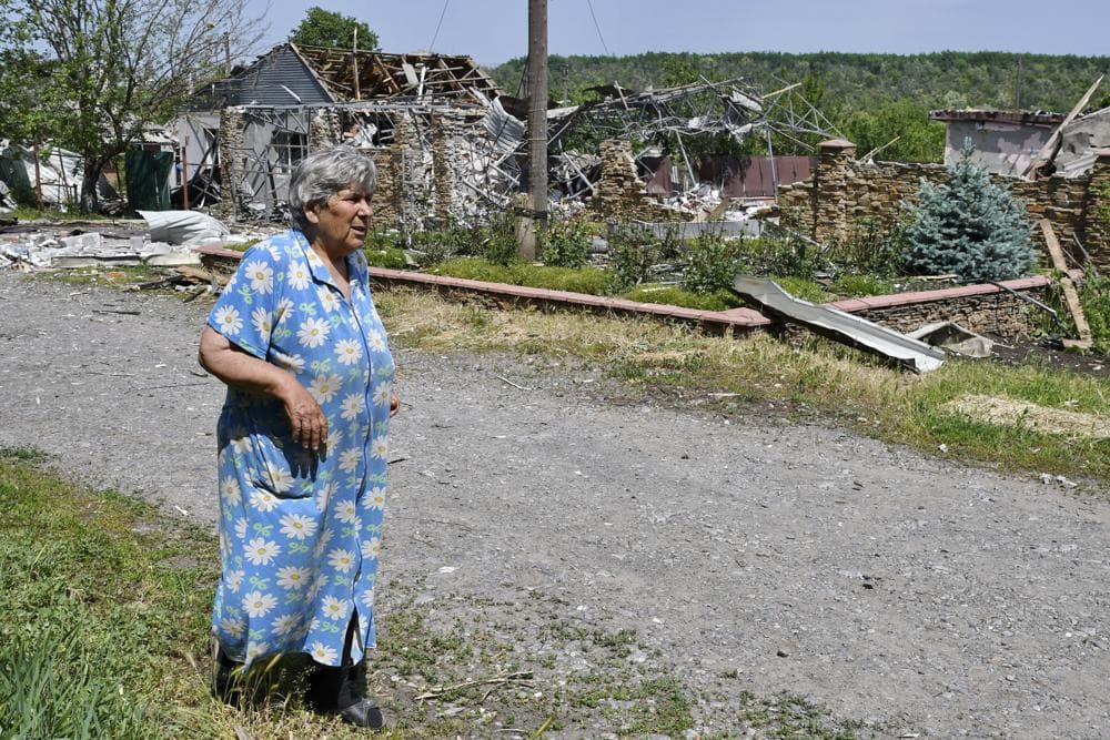 An elderly woman walks past a building damaged by an overnight missile strike in Sloviansk