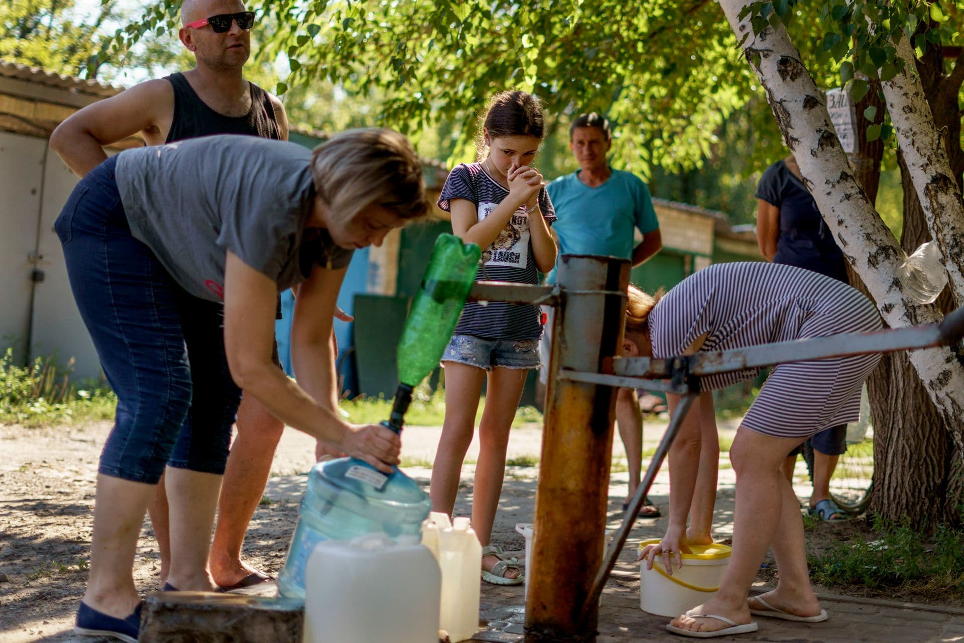 Residents gather to pump water from a well outside an apartment complex in Sloviansk