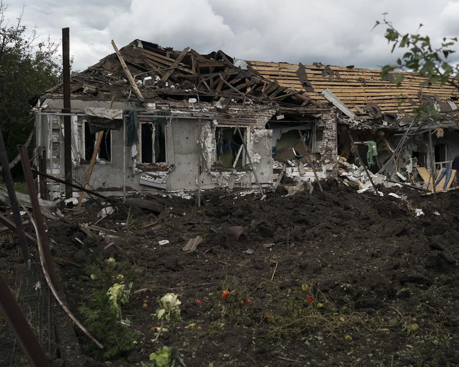 A man walks over the debris of a house that was heavily damaged after a Russian attack in Sloviansk