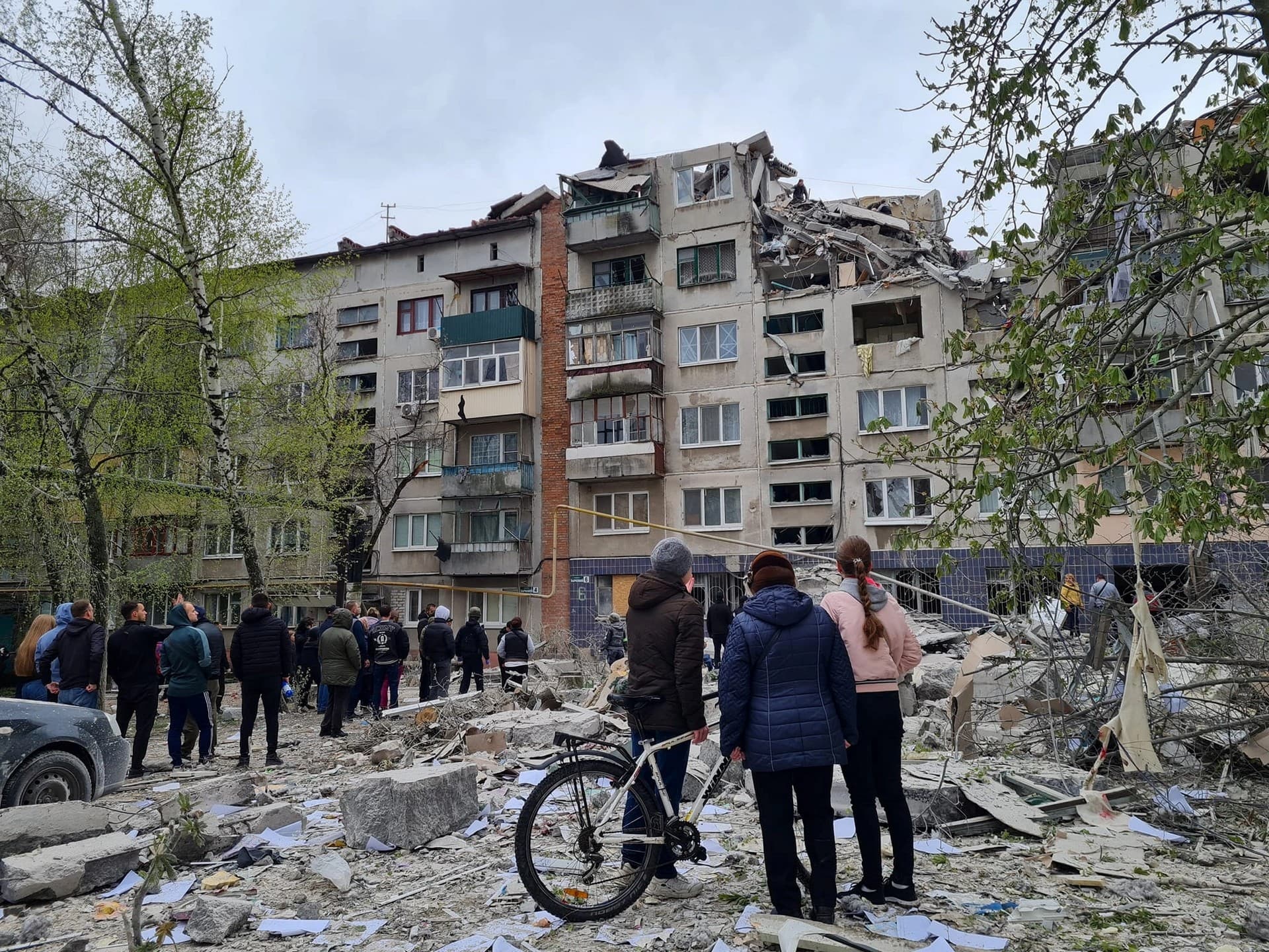 Residents look at an apartment building damaged by a Russian attack in Sloviansk