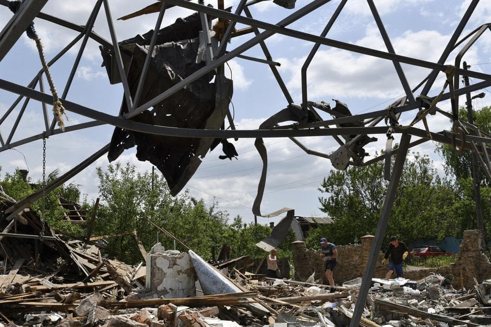 People clean an area of a building damaged by an overnight missile strike in Sloviansk