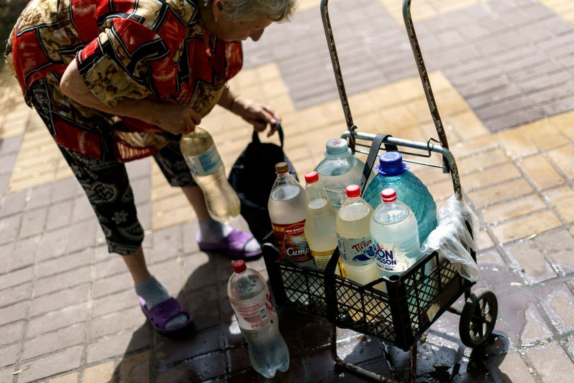 Lyubov Mahlii, 76, packs a crate with water bottles she filled up at a public tank to take back to her apartment in Sloviansk