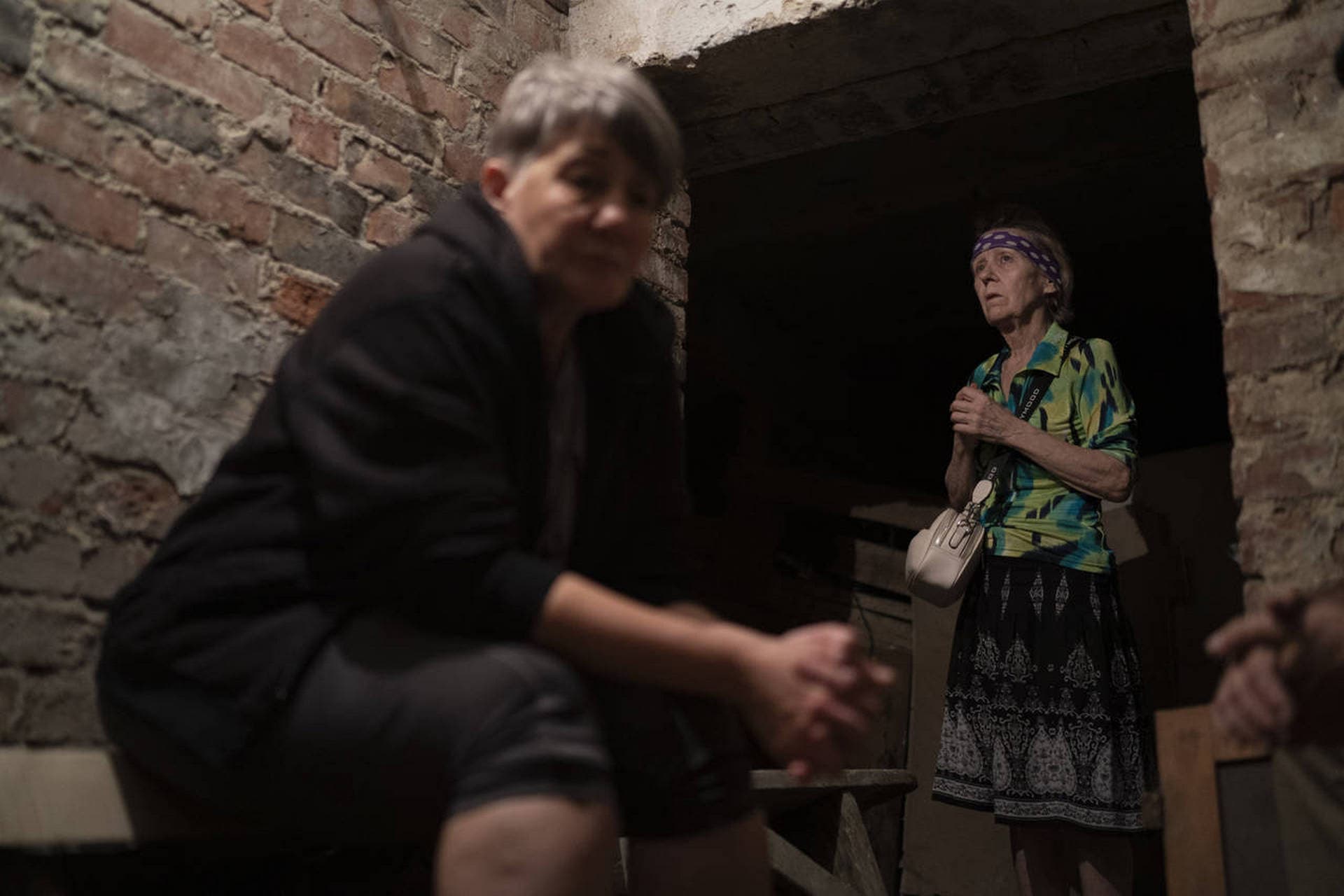 Tetyana, right, takes shelter inside the basement of a residential building during a Russian attack in Sloviansk