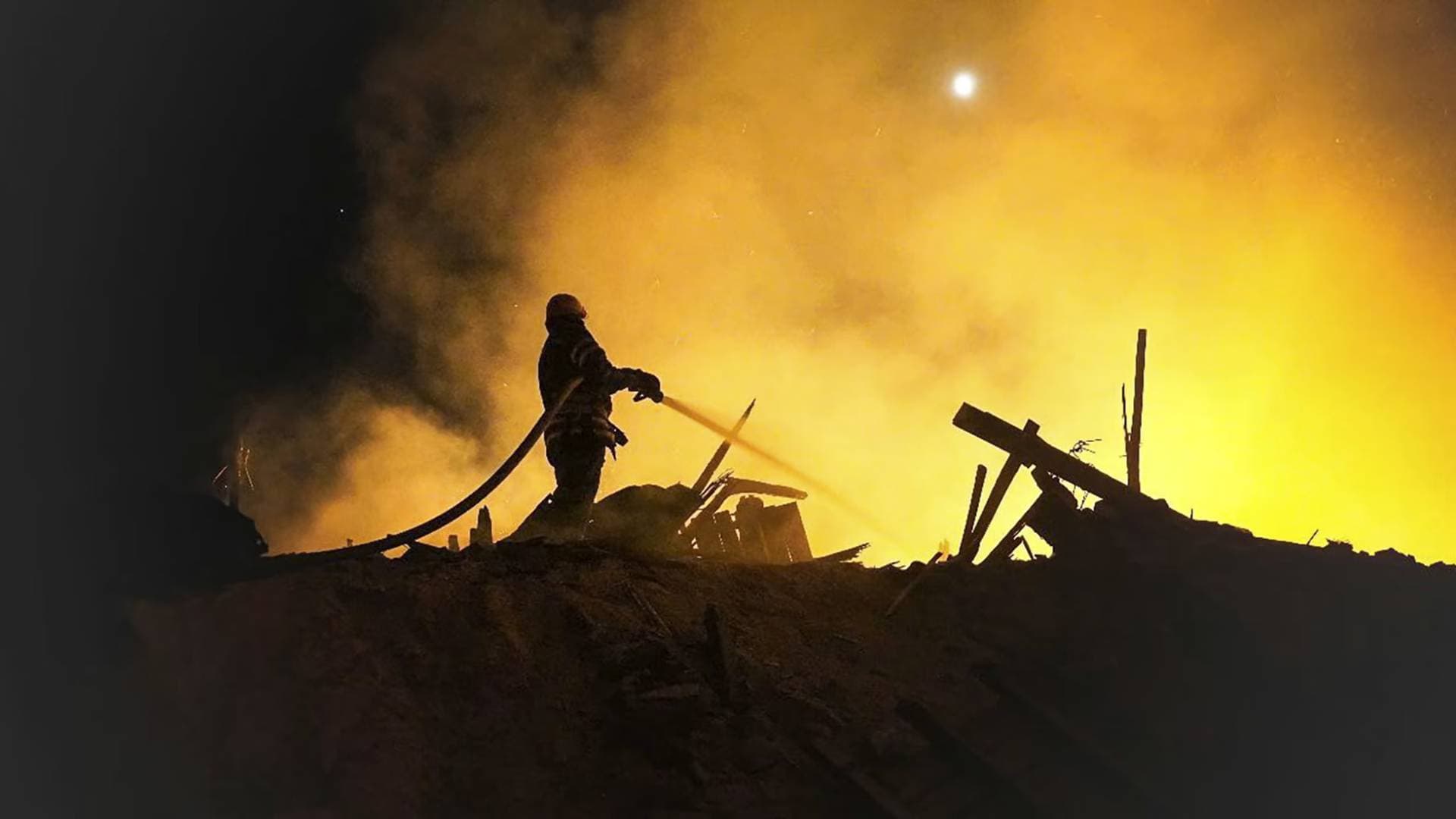 A firefighter extinguishes a fire in the aftermath of an attack given as Starokostiantyniv