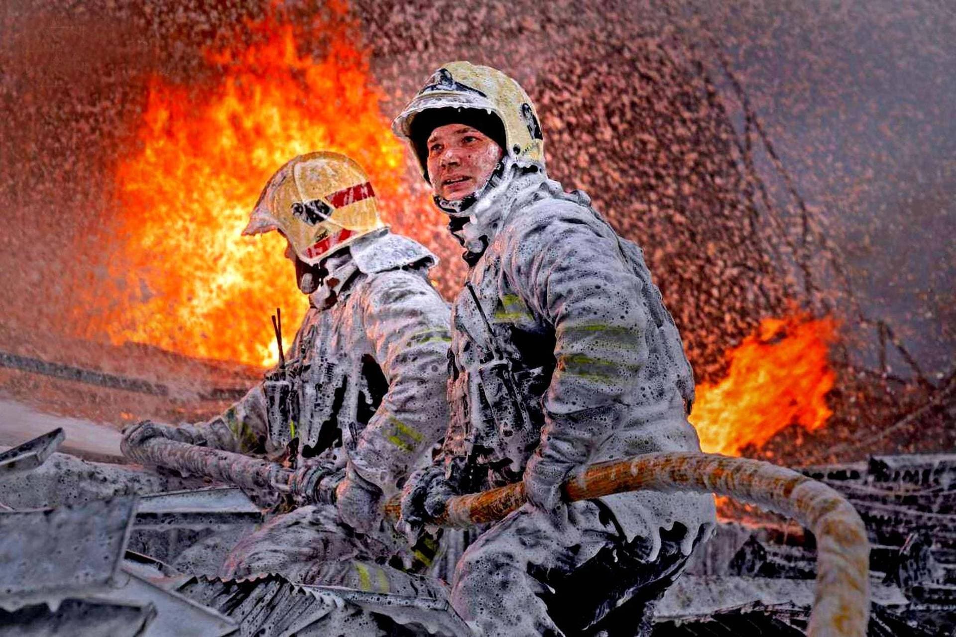 Firefighters work at the site of a building hit by a Russian drone strike in Sumy
