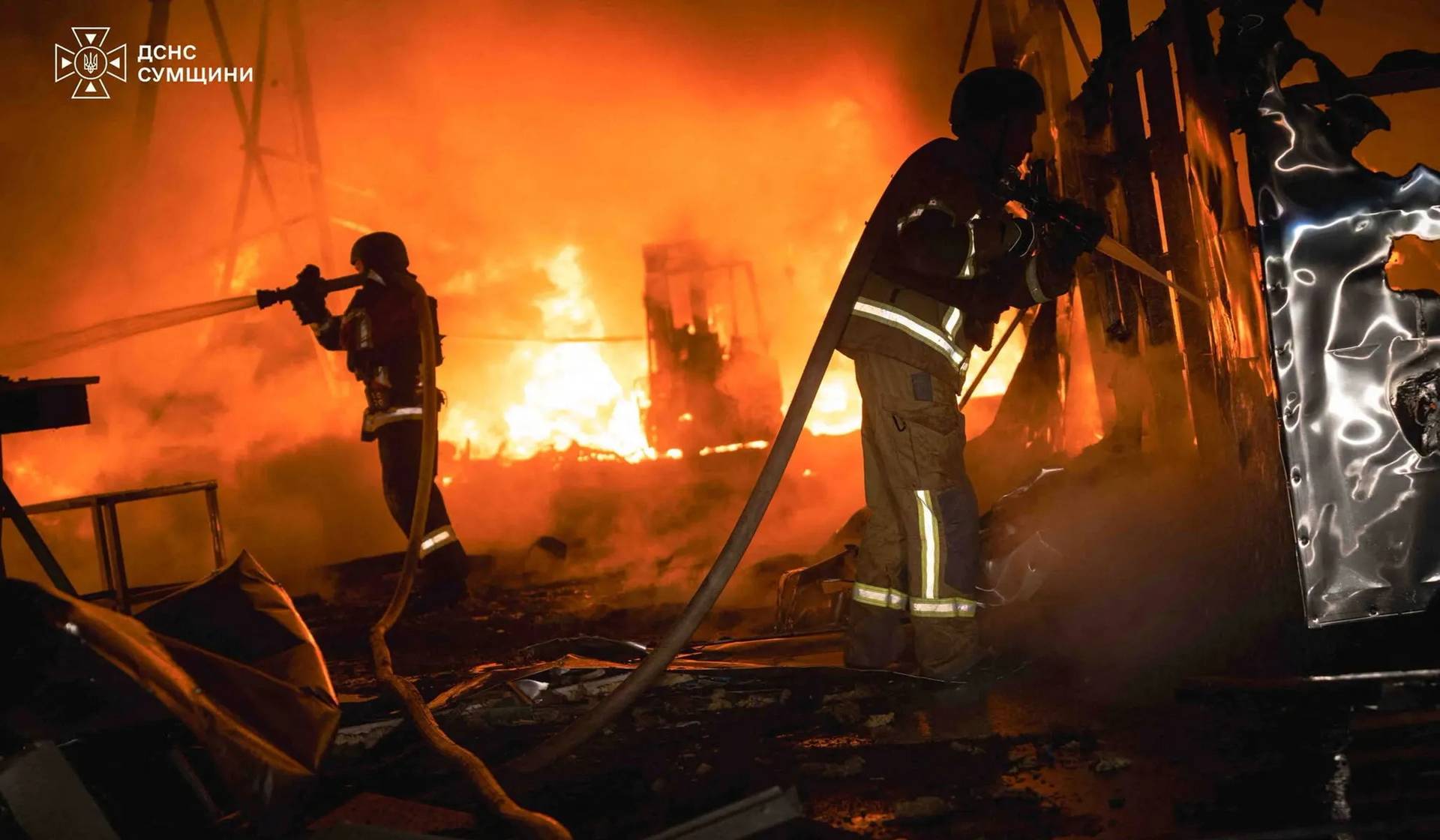 Firefighters work at the site of a warehouse hit by a late evening Russian air strike in Sumy