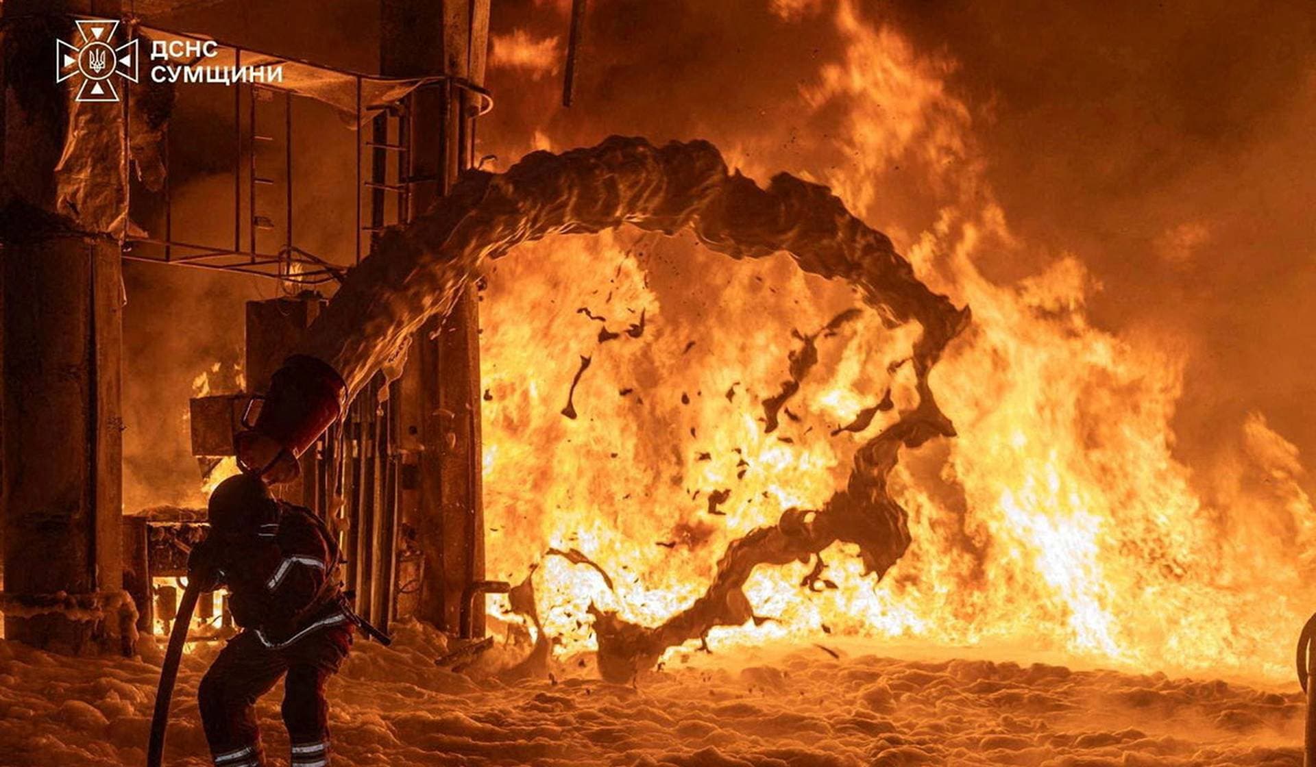 A firefighter works at the site of a petrol station hit by a Russian drone strike in Sumy